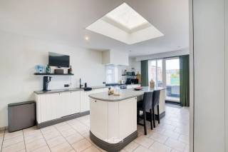Op een boogscheut van het centrum, wandelwegen en het openbaar vervoer bevindt zich deze ruime en instapklare woning. Dankzij de vele natuurlijke lichtinval geniet de woning van een aangename en warme sfeer. De open keuken vormt samen met de leefruimte een gezellige plek en biedt bovendien een mooi zicht op de tuin.<br /><br />De woning beschikt over drie ruime slaapkamers en een verzorgde badkamer met zowel een ligbad als een douche. Daarnaast is er heel wat bergruimte aanwezig, wat zorgt voor extra praktisch comfort.<br /><br />Een absolute troef is de ruime garage, die niet alleen geschikt is voor het stallen van fietsen, brommers en moto's, maar ook voldoende plaats biedt voor gereedschap en allerhande materiaal.<br /><br />Ook op technisch vlak werd de woning goed onderhouden en vernieuwd. Zo werd het dak vernieuwd, zijn er zonnepanelen aanwezig en werd de condensatieketel vernieuwd. Daarnaast zorgt een warmtepomp voor het warme water.<br /><br />Buiten kunt u genieten van een grote, verzorgde tuin en een aangenaam terras, ideaal om tot rust te komen of gezellig samen te genieten van mooie dagen.<br /><br />Deze woning combineert ruimte, comfort en praktische voorzieningen met een uitstekende ligging nabij het centrum, wandelwegen en openbaar vervoer. Een ideale thuis voor wie op zoek is naar een verzorgde woning waar u zonder grote werken meteen kunt intrekken.