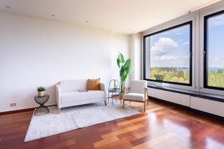Dit appartement is gelegen in de rustige en residentiële Esmoreitlaan op Linkeroever, in de Habitim Tower. Vanuit deze locatie woont u in een groene omgeving, maar toch vlak bij het centrum van Antwerpen. De Schelde, de wandeldijk en het Sint-Annastrand bevinden zich op wandelafstand, ideaal voor een ontspannende wandeling of fietstocht. Ook winkels, scholen en openbaar vervoer zijn vlot bereikbaar. De hoge ligging van het appartement zorgt daarnaast voor een prachtig uitzicht over de Schelde en de skyline van Antwerpen. Dit aangename appartement bevindt zich op de twaalfde verdieping van de Habitim Tower. De ruime leefruimte van 33 m² is afgewerkt met een parketvloer en geniet dankzij de grote raampartijen van een aangename lichtinval. De keuken sluit aan op de leefruimte en is uitgerust met de nodige toestellen. Het appartement beschikt over twee slaapkamers van respectievelijk 16,5 m² en 10 m², beide voorzien van een laminaatvloer. Vanuit beide slaapkamers heeft u toegang tot het ruime terras van 13,5 m². Dankzij de elektrische zonneluifel kunt u hier op zonnige dagen aangenaam vertoeven en volop genieten van het prachtige uitzicht. De badkamer beschikt over een ligbad en een dubbele lavabo. Het toilet is apart en voorzien van een handenwasser. Daarnaast beschikt het appartement over een privatieve kelderberging, ideaal als extra opbergruimte.