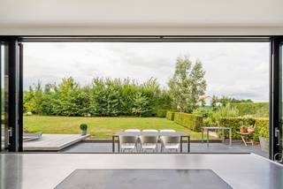 Op de gegeerde grens tussen Grimbergen en Meise bevindt zich deze stijlvolle vrijstaande woning, discreet verscholen in een prachtig aangelegde tuin van maar liefst 25a 66ca. Hier gaan rust, privacy en verfijnd wonen hand in hand met een uitstekende bereikbaarheid richting Brussel, Antwerpen en de luchthaven.<br /><br />Deze smaakvol gerenoveerde villa slaagt erin hedendaags wooncomfort op harmonieuze wijze te verenigen met de authenticiteit en ziel van de oorspronkelijke architectuur. Het resultaat is een woning met een warme uitstraling, een doordachte indeling en een uitzonderlijke woonbeleving.<br /><br />De charmante inkomhal verwelkomt u in een lichtrijke leefomgeving waar karaktervolle elementen, hoogwaardige afwerkingen en subtiele elegantie samenkomen. De sfeervolle woon- en eetkamer baden in natuurlijk licht en bieden doorheen de seizoenen een prachtig zicht op de omliggende tuin. Authentieke details werden tijdens de renovatie zorgvuldig behouden en dragen bij tot het unieke karakter van de woning.<br /><br />Het absolute pronkstuk van deze villa is zonder twijfel de architecturale Cubex-keuken. Dit Belgische designmerk geldt als een icoon binnen de wereld van exclusieve keukens en staat bekend om zijn tijdloze vormgeving, uitzonderlijke afwerkingsgraad en duurzaam vakmanschap. Hier vormt de keuken veel meer dan een functionele ruimte: ze is een centrale leefplek waar design, gastronomie en gezelligheid samenkomen. Dankzij de grote raampartijen geniet u van een onbelemmerd uitzicht op de tuin en de avondzon, terwijl een discreet geïntegreerde berging en de praktische kelder voor extra comfort zorgen.<br /><br />De voormalige inpandige garage werd omgevormd tot een veelzijdige ruimte die zich perfect leent als bureau, bibliotheek, wellness- of fitnessruimte, atelier, extra slaapkamer of gastenverblijf met eigen badkamer.<br /><br />De eerste verdieping omvat drie ruime slaapkamers van respectievelijk 16 m², 16 m² en 13 m², elk gekenmerkt door een aangename lichtinval en een serene, rustgevende sfeer. De stijlvolle badkamer werd ontworpen als een private wellnessruimte en beschikt over een vrijstaand ligbad en royale inloopdouche.<br /><br />Via een vaste trap bereikt u de volledige tweede verdieping, ingericht als exclusieve mastersuite. Deze privéverdieping vormt een waar toevluchtsoord met een eigen badkamer en biedt een ongeëvenaard gevoel van rust, privacy en comfort.<br /><br />Ook buiten wordt dezelfde hoge kwaliteitsstandaard doorgetrokken. De zorgvuldig aangelegde tuin biedt een sublieme groene setting met verschillende terrassen, een moestuin en een polyvalent bijgebouw. Een plek waar men in alle discretie kan genieten van het buitenleven.<br /><br />Een eigendom met karakter, uitstraling en architecturale coherentie, gelegen op een unieke locatie waar natuur, bereikbaarheid en levenskwaliteit elkaar perfect ontmoeten.<br /><br />Extra troeven<br /><br />• EPC-label B: 122 kWh/m²/jaar<br /> • Elektrische installatie conform tot 18/10/2047<br /> • Hoogwaardige renovatie met respect voor authentieke elementen<br /> • Exclusieve Cubex-keuken, Belgisch designicoon van uitzonderlijke kwaliteit<br /> • Afwerking met duurzame en hoogwaardige materialen<br /> • Polyvalent bijgebouw met tal van mogelijkheden<br /> • Ruime parkeervoorzieningen op eigen terrein<br /> • Zonnige, prachtig aangelegde tuin met optimale privacy<br /> • Exclusieve woonomgeving midden in het groen<br /> • Strategische ligging tussen Brussel en Antwerpen<br /> • Nabij winkels, scholen, openbaar vervoer en belangrijke verbindingswegen