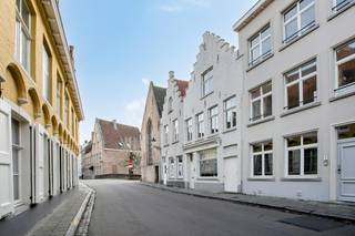 Een hoogwaardig en instapklaar herenhuis met ruime woonvolumes, drie slaapkamers en twee ensuite badkamers, rond een zonnige stadskoer in de Beenhouwersstraat, in het historische hart van Brugge. De leefruimte ligt op de eerste verdieping aan de straatzijde en geniet van veel licht. De slaapkamer op de tweede verdieping kan bovendien worden opgesplitst in twee volwaardige kamers.<br /><br />Met een perceeloppervlakte van 75 m² en een totale bebouwde oppervlakte van 132 m² biedt deze charmante woning verrassend ruime woonvolumes. <br /><br />Gelijkvloers:<br />- inkomhal<br />- Toilet<br />- leefruimte met open keuken<br />- hall met aansluiting wasmachine<br />- zonnige en privatieve stadskoer<br /><br />Eerste verdieping:<br />- slaapkamer met ensuite badkamer <br />- toilet<br />- leefruimte / bureau / slaapkamer<br /><br />Tweede verdiep: <br />- slaapkamer als het ware privésuite met een en-suite badkamer<br /><br />Een unieke kans voor wie stijlvol en comfortabel wil wonen in het centrum van Brugge. In 2023 werd een nieuwe hoogrendementsketel geplaatst. De muren werden extra geïsoleerd in 2025.<br /><br /><br />Bestuursmaatregelen in het maatregelenregister: nee