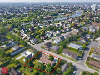 De villa bestaat uit een inkomhal met vestiaire en toilet, living in parket met open haard, open vernieuwde keuken palend aan zonnig terras, afzonderlijke eetruimte, ruime bijkeuken of wasberging, bureel, masterbedroom met dressing met ensuite badkamer, 4 overige slaapkamers, 2de badkamer alsook nog een afzonderlijke douchekamer, polyvalente ruimte of hobbykamer (momenteel bar), zolder, prachtig binnenzwembad met luchtcirculatie, automatische screens en rechtstreeks toegang tot de tuin, volledig onderkelderd (kleedkamers, sauna, doucheruimtes, voorraadkelder, centrale stofzuiger, CV-kelder en wijnkelder). Verder is er de zonnige tuin, verschillende terrassen en dubbele garage.<br />Vervolgens is er een 2de woonst (afzonderlijk huisnummer) zeer geschikt als kangoeroewoning/zorgwoning, kantoren of praktijkruimte, bestaande uit: inkomhal, bureel, wachtplaats, 2 ruime kantoren/kamers/praktijkruimtes, keuken, bergruimte en sanitair. Onnoemelijk veel mogelijkheden bvb voor nieuw samengesteld gezin of zorgwoning (ca 820m² bewoonbare oppervlakte), op wandelafstand van de Leieboorden en Kortrijk centrum! Aarzel niet ons te contacteren voor meer inlichtingen of een vrijblijvend bezoek ter plaatse.