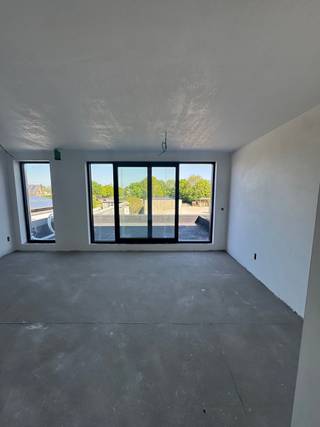Residentie Scheldetuin is gelegen in de Winkelstraat te Puurs-Sint-Amands, op wandelafstand van het charmante centrum van Sint-Amands. Hier vind je alles binnen handbereik: winkels, bakkerijen, slagers en gezellige restaurants. Voor wie graag ontspant, liggen de Schelde en diverse lokale sportclubs vlakbij. Ook het centrum van Puurs en Bornem zijn vlot bereikbaar. Met de bus sta je snel aan het station van Puurs, dat ook gemakkelijk per fiets te bereiken is. Voor gezinnen is dit een ideale locatie: scholen bevinden zich op wandelafstand. De bereikbaarheid met de auto is uitstekend, met de E17 op slechts 10 km en de A12 richting Brussel of Antwerpen op slechts 7 km. Bovendien zet Puurs-Sint-Amands sterk in op de toekomst met een nieuw masterplan voor de Scheldekaaien, wat de aantrekkingskracht van de regio verder vergroot. Residentie Scheldetuin combineert deze topligging met rust en comfort. Aan de achterzijde van het project bevindt zich een groene tuin, ideaal om tot rust te komen. De vijf moderne appartementen zijn uitgerust met zonnepanelen en voldoen aan de BEN-normen, met een E-peil lager dan 20, wat garant staat voor energiezuinig wonen. Bovendien komen de appartementen in aanmerking voor het verlaagde btw-tarief van 6% op de constructie. Dit project valt niet onder de bescherming van de Wet Breyne, wat betekent dat de betaling pas bij oplevering plaatsvindt. Geen schijven op voorhand te betalen! De oplevering is voorzien voor december 2025. Voor meer informatie, bel 052/33.26.86 of mail naar gert@ax-quality.be.