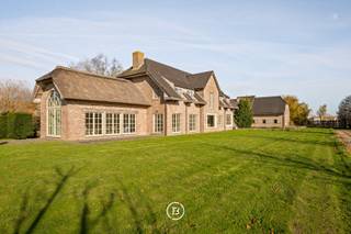 Verscholen in een groen en privatief domein van 1,5 ha bevindt zich dit indrukwekkende landhuis met een bewoonbare oppervlakte van maar liefst 605 m2. Een residentie waar ruimte, rust en karakter samenkomen te midden van de uitgestrekte polders van Middelkerke.<br /><br />Vanaf het moment dat u de eigendom bereikt via de oprijlaan wordt duidelijk dat dit geen alledaagse woning is. De ontvangstruimtes ademen karakter en werden ingericht met kwalitatief maatwerk waardoor een warme en stijlvolle leefomgeving ontstaat. De charmante orangerie of bibliotheek biedt een unieke plek om te genieten van de vergezichten over het eigen domein. De landelijke leefkeuken vormt het hart van de woning en sluit naadloos aan op de verschillende leefruimtes. Royale raampartijen brengen het omliggende landschap tot diep in de woning en zorgen voor een voortdurende verbinding met het buitenleven. <br /><br />De verdieping werd ingericht met een royale mastersuite, aanvullende slaapkamers, meerdere badkamers en diverse dressingmogelijkheden. Met een bewoonbare oppervlakte van 605 m2 en een bijzonder flexibele indeling biedt deze eigendom tal van mogelijkheden voor uiteenlopende woonconcepten. De inrichting van een volwaardige kangoeroewoning behoort hier zonder meer tot de mogelijkheden, waardoor verschillende generaties comfortabel kunnen samenleven met behoud van hun privacy.<br /><br />Op het domein bevindt zich bovendien een bijgebouw van 94m2 dat vandaag dienst doet als garage voor meerdere wagens. Voor paardenliefhebbers zijn er drie paardenboxen en een aangelegde piste aanwezig waardoor het geheel perfect aansluit bij een landelijke levensstijl.<br /><br />Dit is een eigendom voor wie op zoek is naar ruimte in haar meest luxueuze vorm.