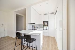 Locatie:
Sommige plekken voelen meteen vertrouwd. Dit appartement ligt op de eerste verdieping van een karaktervol hoekgebouw in de Kanunnikenstraat, in de Antwerpse wijk Kiel. Scholen, winkels en de huisarts vind je om de hoek, en op vijf minuten wandelen sta je in het groen van het Kielpark. Vanaf de tramhalte Kielpark rijd je zo naar het stadscentrum, het station Antwerpen-Zuid ligt op zes minuten fietsen en het levendige Zuid op een tiental minuten. Met de wagen zit je snel op de Ring en de A12.

Indeling:
In de ruime leefruimte valt het licht langs verschillende kanten binnen, dankzij de vele ramen van dit hoekgebouw. Aansluitend ligt de moderne open keuken met ontbijttoog en inbouwtoestellen: de plek voor een snelle koffie in de ochtend of een babbel terwijl het eten op het vuur staat.

Via de hal bereik je de twee slaapkamers van ca. 17 m² en 7 m². Een extra multifunctionele ruimte is nu ingericht als slaapruimte, maar wordt even goed je bureau, dressing of hobbyruimte. De moderne badkamer is uitgerust met een inloopdouche, wastafel en toilet.

Kelder en garage: een private kelder biedt extra opbergruimte. Daarnaast kun je afzonderlijk een of twee garageboxen aankopen, zodat je in de stad nooit naar een parkeerplaats hoeft te zoeken. Van een ontbijt aan de toog tot een avond in je eigen hoekje: hier krijgt elk moment zijn plek.

Troeven:

Lichtrijke leefruimte met ramen aan verschillende zijden
Moderne open keuken met ontbijttoog en inbouwtoestellen
Twee slaapkamers van ca. 17 m² en 7 m²
Extra multifunctionele ruimte – bureau, dressing of hobbyruimte
Hedendaagse badkamer met inloopdouche
Private kelder en optie op twee garageboxen

Technische gegevens:
Het appartement beschikt over individuele centrale verwarming op gas en PVC-ramen met thermische dubbele beglazing, voor een warm en comfortabel interieur. Een parlofoon is aanwezig.

Extra:
Garageboxen: twee garageboxen, afzonderlijk aan te kopen aan € 25.000 per stuk

Benieuwd naar de waarde van je woning? Vraag een gratis schatting aan via lex@bauwensvastgoed.be