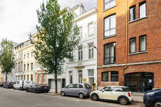In het hart van Antwerpen, bevindt zich deze prachtige herenwoning met een bijzonder karakter en een indrukwekkende hoeveelheid ruimte. De voormalige dokterswoning combineert authentieke elementen met hedendaags wooncomfort en biedt dankzij haar veelzijdige indeling tal van mogelijkheden.<br /><br />Via de statige inkomhal betreden we het gelijkvloers, waar zich momenteel een afzonderlijke winkel- en atelierruimte bevindt. Ideaal voor wie een vrij beroep beoefend of simpelweg terug te brengen als woonfunctie. Achteraan geniet de woning van een rustige stadstuin van ca. 30 m², een aangename plek om even te ontsnappen aan de stadsdrukte.<br /><br />De eerste verdieping vormt het hart van de woning. Hier bevindt zich de bijzonder ruime woon- en leefruimte, waar de authentieke elementen de grandeur van het pand extra in de verf zetten. Aansluitend vinden we de open, volledig ingerichte keuken, uitgerust met alle nodige toestellen. Vanuit de keuken bestaat bovendien de mogelijkheid om via de trap toegang te creëren tot de tuin. Een afzonderlijk gastentoilet vervolledigt deze verdieping.<br /><br />Op de tweede verdieping bevindt zich de master bedroom met zijn aparte dressing, voorzien van kwalitatief maatwerk., Ruime master bathroom met ligbad, douche en dubbele wastafel met meubel. Daarnaast vinden we op deze verdieping een tweede slaapkamer met eigen badkamer, uitgerust met een douche, enkele wastafel en toilet. Een afzonderlijk gastentoilet is eveneens aanwezig.<br /><br />Op de tussenverdieping bevindt zich een ruim, zuidgericht zonneterras, waar het heerlijk vertoeven is!<br /><br />De derde verdieping biedt nog twee volwaardige slaapkamers, elk met een eigen ensuite badkamer. Daarnaast werd hier een kitchenette geïnstalleerd, die tot op heden niet in gebruik werd genomen. Deze verdieping leent zich uitstekend voor studerende kinderen, het ontvangen van gasten of eventueel voor een afzonderlijke invulling, zoals kamerverhuur of toeristische logies, mits naleving van de geldende regelgeving en eventuele vergunningsvereisten.<br /><br />Tot slot beschikt de woning over een praktische kelderberging.<br /><br />Met haar authentieke uitstraling, vier slaapkamers met elk een eigen badkamer, een afzonderlijke commerciële ruimte en twee aangename buitenruimtes biedt deze uitzonderlijk ruime herenwoning een bijzondere combinatie van wonen en werken op een centrale locatie in Antwerpen.<br /><br />De uitgesproken en karaktervolle inrichting geeft de woning vandaag een eigen identiteit, terwijl de authentieke elementen en indrukwekkende ruimtes een prachtige basis vormen om het geheel volledig naar eigen smaak in te richten.