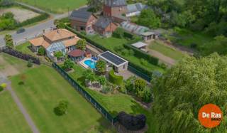 BEZOEKDAG ZATERDAG 1 AUGUSTUS VANAF 10U (ENKEL OP AFSPRAAK!!)<br />SINT-LIEVENS-HOUTEM - Spaanse villa met zwembad <br /><br />Droomt u van een woning met een permanente vakantiesfeer? Dan zal deze unieke villa in Sint-Lievens-Houtem u meteen weten te bekoren. Gelegen op een ruim perceel van maar liefst 2.151 m² combineert deze eigendom royale leefruimtes, hedendaags comfort en een prachtig aangelegde tuin met zwembad.<br /><br />De woning beschikt over een ruime bewoonbare oppervlakte van circa 250m² en biedt een bijzonder praktische indeling. Via de inkomhal bereik je zowel toilet, garage als de leefkamer. <br />De keuken is volledig ingericht en heeft een bijkomende keukenberging/wasplaats. <br /><br />Buiten waant u zich in een zuiders vakantieoord. De tropisch aangelegde tuin vormt samen met de gezellige patio, het zwembad, de pergola en de jacuzzi een unieke plek om te ontspannen en te genieten met familie en vrienden. <br />De parktuin met bijgebouwen maakt dit tot een compleet aanbod. <br /><br />Ook op vlak van energie en technologie scoort deze woning goed dankzij de aanwezigheid van zonnepanelen, een thuisbatterij en een laadpaal voor elektrische voertuigen.<br /><br />Troeven:<br />- 3 slaapkamers en 2 badkamers<br />- Vernieuwde badkamer op het gelijkvloers<br />- Ruime inpandige garage<br />- Deels onderkelderd en voorzien van kruipkelder<br />- Tropische tuin met patio, zwembad, jacuzzi en pergola<br />- Bijgebouw van 46 m² als buitengarage, opberg en technieken. <br />- Unieke zuiderse architectuur met uitgesproken karakter<br /><br />Voor meer informatie of een bezoek, kan u ons steeds contacteren: 053/60.65.60.