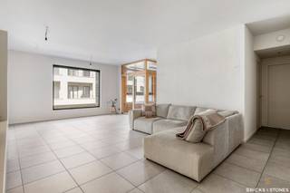 Knap en recent appartement gelegen in de gegeerde Cadixwijk.<br /><br />Dit verzorgde appartement bevindt zich op de tweede verdieping van een recent gebouw. Je komt binnen via de ruime inkomhal, waar zich ook een praktische berging met aansluiting voor wasmachine en droogkast bevindt, evenals een privatief gastentoilet.<br /><br />De zeer ruime woon- en leefruimte van ca. 33 m² baadt in het licht en sluit aan op een extra open ruimte van ca. 9 m², die perfect kan dienen als bureau, leeshoek of speelhoek.<br /><br />De open, volledig ingerichte keuken is uitgerust met kwalitatieve AEG-toestellen, waaronder een koelkast met vriesvak, inductiekookplaat, vaatwasser en combi-oven. Aansluitend aan de keuken bevindt zich een overdekt terras/veranda, ideaal om open te zetten tijdens de eerste lentestralen of te gebruiken als aparte werkruimte.<br /><br />Via de nachthal bereik je twee volwaardige slaapkamers (ca. 15 m² en 10 m²). De master bedroom beschikt bovendien over een en-suite dressing. De moderne, aparte badkamer is ingericht met een douche en een enkele lavabo.<br /><br />Tot slot is er de mogelijkheid om een autostaanplaats én motostaanplaats bij te huren aan €150/maand.<br /><br />Het appartement is beschikbaar vanaf 01/03/2026 en geschikt voor maximaal 3 personen.