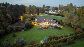 In het afgesloten en residentiële domein “Vlieringenpark” bevindt zich deze unieke villa, ontworpen in een verfijnde Scandinavische architectuurstijl en genietend van een prachtig, open vergezicht.<br /><br />De woning combineert een Scandinavisch design, natuurlijke materialen en functionaliteit en biedt bovendien tal van mogelijkheden, zoals het inrichten van een aparte studio voor een au pair of een bureau voor een vrij beroep.<br /><br />Indeling:<br />Gelijkvloers (0): Inkomhal met vestiaire en gastentoilet, ruime leefruimte met zithoek en eetplaats, volledig uitgeruste keuken met bijkeuken, veranda, masterbedroom met dressing en ensuite badkamer, wasplaats, berging en atelierruimte.<br />Verdieping (+1): mezzanine met bureauruimte, twee slaapkamers met ensuite badkamer, kinderkamer en extra opbergruimte.<br />Zolder (+2): opbergzolder.<br />Kelder (-1): wijnkelder en 3 ruime kelderruimtes.