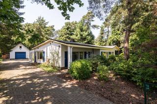 <strong>Deze goed onderhouden vrijstaande woning met garage is fraai gelegen in een bosrijke en rustige villawijk nabij de Nederlandse grens.<br />De woning beschikt over o.a. 3 slaapkamers en 2 badkamers , allen op de begane grond. <br />De oppervlakte van het zuid gelegen perceel is 1.588 m² en bestaat uit een bostuin rondom en een vrijstaande garage met bergzolder achterop het perceel.<br /><br /></strong>Indeling begane grond: <br />De ruime hal geeft toegang tot de lichte woonkamer. Deze is voorzien van parketvloer en open haard. Achter de woonkamer is de serre/tuinkamer met zicht over de tuin en voorzien van schuifdeuren.<br />De keuken is gelegen aan de achterzijde van de woning en heeft fraai uitzicht over de tuin. De keuken is voorzien van diverse inbouwapparatuur.<br />Aangrenzend aan de keuken is er een praktische berging/bijkeuken waar ook de cv ketel geplaatst is ( gas -HR)<br /><br />Verder bevinden zich op de begane grond een gastentoilet en twee slaapkamers met een vernieuwde badkamer voorzien van inloopdouche en wastafelmeubel. Via een hal met op maat gemaakte kasten is de grootste en derde slaapkamer te bereiken. Deze kamer ligt aan de achterzijde en heeft een schuifdeur naar de tuin. Deze kamer heeft een eigen ruime badkamer voorzien van ligbad, douche, wastafel en toilet.<br /><br />Garage: Vrijstaande garage, gebouwd in 1999, voorzien van praktische bergzolder en voorzien van een automatische poort. <br />De garage is voorzien van een laadpaal voor een electrische auto.<br /><br />Buitengebeuren: Privacy biedende bostuin rondom met meerdere terrassen, tuinhuis en voldoende parkeerruimte op de eigen oprit.<br /><br />Bijzonderheden: <br />- De woning is uitbebreid en verbouwd in 1990.<br />- Verwarming op aardgas ( HR ketel)<br />- Houten kozijnen met dubbel glas.<br />- Dakbedekking ( bitumen) is in 2024 vernieuwd.<br />- Spouwmuurisolatie en plafondisolatie<br />- EPC label D ( geen renovatieplicht)<br />- Goedgekeurde electriciteit<br />- Gunstige ligging nabij Nederlandse grens<strong><br /><br /></strong>