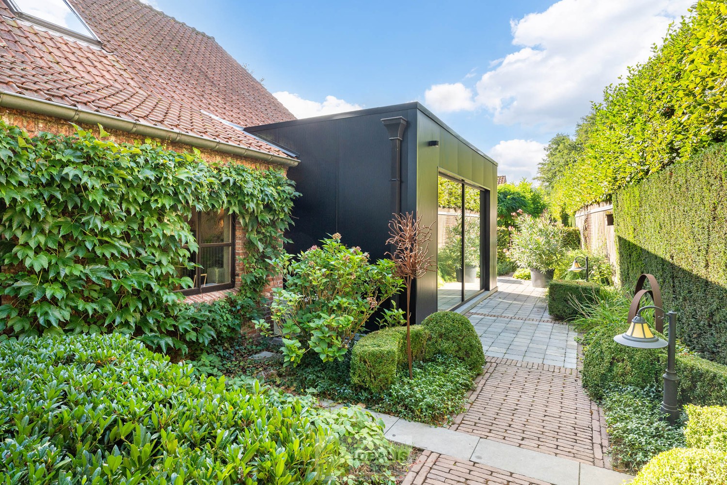 IDYLLISCH GELEGEN BIJZONDERE EIGENDOM BESTAANDE UIT RIANT WOONHUIS, APART BEWOONBAAR BIJGEBOUW EN ATELIER OMGEVEN DOOR EEN SCHITTERD AANGELEGDE TUIN EN WEILAND. Het domein is toegankelijk zowel aan de mooie Urnenveldstraat doch ook via een uitzonderlijk m - foto 4