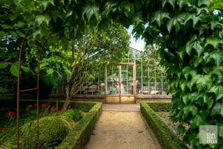 On the ground floor, the villa offers a high entrance hall with guest toilet and checkroom. This entrance hall provides access through a double door to the spacious living room with wood burning stove and furnished with sitting and dining area. Adjacent to the living space is the fully equipped kitchen. Furthermore, the ground floor offers a master bedroom with private bathroom and fitted wardrobes, indoor garage for one vehicle, and a studio with kitchenette, bathroom, living room/bedroom and fitted wardrobes. <br /><br />The second floor was fully furnished as an apartment with living room, sitting area/winter garden overlooking the balcony, fully equipped kitchen, night hall, separate toilet, 2 bedrooms, a bathroom, and a storage room with connections for washer and dryer. Via a separate staircase in the garage on the ground floor you can also reach a 5th bedroom or hobby room. This last room was also equipped with a sink.<br /><br />The house has a full basement and offers a wine cellar, a central heating room, several storage rooms and an indoor garage. The garage in the basement can be accessed via a ramp at the rear, although it is only used as garden storage since the ramp is not suitable for a car.<br /><br />The spacious park garden is fully landscaped and fenced and features cobblestone paving, several terraces and a conservatory with grape vines.