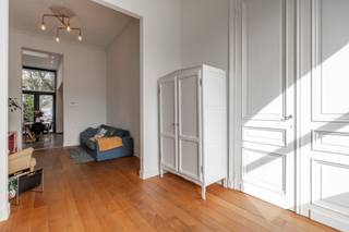 <p>Welkom in de Uitbreidingstraat, midden in het gezellige Oud-Berchem met het groen verrassend dichtbij.<br />Achter de charmante gevel wacht een woning waar oud en nieuw elkaar duidelijk goed gevonden hebben.<br />We beginnen in de inkomhal. De originele deuren, sierlijsten en speelse tegelvloer zetten meteen de toon. Achteraan de hal ligt er een handig eerste toilet.<br />Links loopt de leefruimte bijna over de volledige diepte van de woning. Hoge plafonds, parket, veel licht en mooie authentieke details zorgen voor dat typische herenhuisgevoel.</p>
<p>En dan komen we achteraan in de royale leefkeuken die zonder twijfel een van onze favoriete plekken is. Strak en volledig uitgerust. En die plafondhoogte? Die doet de rest.<br />Een grote tafel, familie en vrienden errond, iets lekkers op het vuur… dit is zo'n keuken waar het leven vanzelf blijft plakken.<br />Via de dubbele ramen stap je de stadskoer van 18 m² op. Omringd door bakstenen muren en groen voelt het hier heerlijk beschut. Ontbijt buiten, barbecue aan, glaasje erbij. Meer moet een stadstuin soms niet zijn.</p>
<p>Terug naar binnen en een halve verdieping hoger.<br />Daar wacht een badkamer die gerust wat aandacht mag opeisen. Een vrijstaand ligbad, grote inloopdouche en dubbele lavabo, met zicht op het groen. Ernaast bevindt zich nog een apart gastentoilet.</p>
<p>Op de eerste verdieping liggen twee mooie kamers. Slaapkamers, kinderkamers, bureau… ze laten zich gemakkelijk aanpassen aan wie hier straks woont.<br />En dan helemaal naar boven.<br />Daar heeft de master bedroom zich verstopt onder het dak.<br />En die is royaal. Met veel licht en meer dan genoeg ruimte voor een dressing, een bureau of allebei. Niemand heeft ooit gezegd dat je moet kiezen.</p>
<p>Ook technisch werd de woning grondig aangepakt. Een nieuw dak, nieuwe leidingen, dubbele beglazing, condensatieketel, conforme elektriciteit, een asbestvrij attest en EPC B. <br />En alsof dat nog niet voldoende praktische punten zijn, is er ook nog een kelder.</p>
<p>En dan is er Oud-Berchem zelf, een buurt waar stad en groen verrassend goed samengaan. Vanuit de woning kijk je uit richting Wolvenberg, terwijl ook het Villegaspark vlakbij ligt.<br />Verder zijn hier tal van leuke adresjes in de buurt en blijft de stad binnen handbereik. Je woont hier stedelijk, maar zonder dat typische gevoel dat je midden in de drukte zit.</p>
<p>Troeven: <br />- charmante gerenoveerde woning <br />– Oud-Berchem, vlakbij Wolvenberg en Villegaspark<br />– royale leefkeuken <br />– stadskoer<br />– mooie badkamer <br />– authentieke elementen <br />– hoge plafonds <br />– parket <br />– kelder <br />– nieuw dak & leidingen <br />– EPC B, AREI conform & asbestvrij</p>