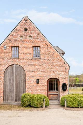‘Hof ter Beeldeken’ - Estate ‘Grote Spaandervoorthoeve anno1607’ with an area of 34,061m² and possible expansion<br /><br />Exclusive villa at Vrieselhof – Future proof renovated<br /><br />Located on the border of Schilde and Oelegem, in line with the prestigious Vrieselhof castle domain, this exceptional authentic farmhouse is situated on a fully fenced domain of over 3 hectares. A rare combination of rural heritage, timeless elegance, and contemporary living comfort of the highest level — perfectly located 3 minutes from the center of Schilde, with easy access to the motorway and all major roads.<br /><br />Total renovation with attention to every detail<br />The farmhouse was completely stripped and rebuilt from the ground up under architectural leadership, in the refined style of Axel Vervoordt. Only high-quality materials were used, while authentic elements — beautiful old wooden beams, rounded walls, craftsmanship techniques — were harmoniously integrated into a refined finish. Atmosphere and character seamlessly blend with modern comfort.<br />The renovation was consistently future-proof: fully insulated, equipped with geothermal energy for heating and swimming pool, underfloor heating and passive cooling, fireplaces with heat recovery, home automation, LED lighting, garden irrigation. Oak floors, wooden windows with horn handles — every detail reflects a high-quality new construction vision with respect for the authentic character.<br /><br />Living spaces of exceptional class<br />The heart of the home is the spacious, fully customized living kitchen, hyper-equipped with a La Cornue stove; induction hob, gas hob, and gas oven, electric oven, grill, and warming plate, Miele steam oven, microwave oven, and a large cooling island with a dishwasher. Furthermore, there are full custom cabinets with the same finish continued inside.<br />An elegant wrought iron conservatory is attached, with curved, insulated, and reinforced glass, which bathes in natural light all year round and offers a panoramic view of the garden and surrounding greenery.<br />Adjacent is a TV room with a fireplace and Bose surround system for cozy evenings, and an impressive living room around an authentic, 400-year-old fireplace with extraction system and heat recovery — also usable as an extra dining room. A third spacious room with a fireplace offers all the freedom as a studio, library, or hobby room.<br />On the ground floor, there is also a guest room with its own shower room.<br />The finished basement houses a laundry room, technical room, a versatile space for a wine or hobby cellar, and all technical installations.<br /><br />Sleeping floor<br />The main staircase leads to the master suite, a comfortable bedroom, a spacious dressing room with an island, and a luxurious bathroom with Dronbracht faucets, with a freestanding bath, double rain shower, two sinks, and a toilet.<br />Furthermore, there is a stylish bedroom with its own shower room, sink, and toilet.<br /><br />A second staircase provides access to two spacious bedrooms with built-in wardrobes and a desk area, a bathroom with a bath and double sink, and a separate toilet.<br />The entire upper floor is passable and can be compartmentalized.<br />The bedrooms and kitchen are equipped with air conditioning.<br /><br />A large annex with three folding wooden doors to the private garden currently serves as storage space. An exceptional asset is that it is already prepared for an indoor swimming pool 9 X 4m with wellness: the pool shell is ready under the easily removable floor, making the possibilities real and highly accessible.<br /><br />Outdoor living &amp; special features<br />The estate also convinces outside the walls with over 1 ha of landscaped park garden with easy maintenance and walking paths with chestnut wooden fencing and 10 access gates.<br />The garden is fully fenced and equipped with LED garden lighting from Royal Botania, according to a lighting study.<br />A beautiful infinity outdoor pool in mosaic of 12.5m X 5m with a hidden cover, a tennis court, and beautifully landscaped green areas and terraces in blue stone make this property a true holiday destination on its own grounds.<br />A wooded area on the plot guarantees absolute privacy and an intense feeling of nature.<br />Horse lovers are particularly spoiled here: the property has a horse location near the villa and another location on the estate with direct access to the surrounding bridle paths.<br />The estate is a perfect base for riders. The extensive network of walking, cycling, and horse-riding routes literally starts at the door.<br /><br />6 parking spaces on its own grounds with charging function (380v) for electric cars.<br /><br />Unique in its kind<br />This exclusive farmhouse is a harmonious mix of artisanal perfection, technological innovation, and timeless elegance on an exceptional domain of more than 30,000 m² of land and 5 minutes from Schilde.<br /><br />A property where peace, space, and refined comfort come together in an environment of rare beauty.<br /><br />Extraordinary features<br />- Total energetic Future Proof renovation<br />- High-End detail finishing and materials: Oak Parquet Corvelyn, Burgundian