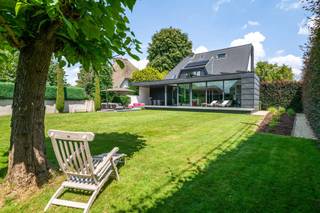 <h3>Energiezuinige villa met luxe afwerking en zonnige tuin (ca. 1.183 m²)</h3>
<p>Deze instapklare villa werd de voorbije jaren grondig gerenoveerd en biedt een perfecte mix van ruimte, comfort en energie-efficiëntie. Denk aan een prachtige uitbouw met overdekt terras, een nieuw dak, zonnepanelen met thuisbatterij, nieuwe gevelisolatie en tal van op maat gemaakte kasten en details. <br /><br /><strong>Gelijkvloers</strong></p>
<ul>
<li><strong>Inkomhal</strong>: Ruime ontvangsthal met gastentoilet. Vernieuwde trap met indirecte verlichting.</li>
<li><strong>Leefruimte</strong>: Sfeervolle en zeer ruime woonkamer, ingedeeld in een zithoek met houtkachel, eetkamer en een bureauhoek in de uitbouw. Grote raampartijen met automatische zonnewering bieden prachtig zicht op de tuin en toegang tot het overdekte terras.</li>
<li><strong>Keuken</strong>: Moderne, volledig uitgeruste open keuken met een geïntegreerde led-tv achter de kookplaat. Via een verborgen deur is er toegang tot een wijnkelder.</li>
<li><strong>Praktische ruimtes</strong>: Achteraan bevinden zich een berging met wasplaats (aparte zij-ingang) en een douchekamer met inloopdouche, lavabo en toilet, ook toegankelijk vanaf het overdekt terras.</li>
</ul>
<p><strong>1e verdieping</strong></p>
<ul>
<li><strong>Hoofdslaapkamer</strong>: Recent vernieuwde ouderslaapkamer met aanpalende dressing. Instant hotelsuite gevoel!</li>
<li><strong>Kinderkamers</strong>: Drie comfortabele slaapkamers, allen voorzien van maatkasten en op maat gemaakt meubilair.</li>
<li><strong>Badkamer</strong>: Luxe badkamer met ligbad, inloopdouche en dubbele lavabo.</li>
<li><strong>Extra</strong>: Nachtal met maatkasten en apart nachttoilet.</li>
</ul>
<p><strong>2e verdieping</strong></p>
<ul>
<li><strong>Zolderkamer</strong>: nachthal met maatkasten en toegang tot de vijfde slaapkamer met ingebouwd bed en extra bergruimte.</li>
<li><strong>Zolderberging</strong></li>
</ul>
<p><strong><br />TUIN</strong></p>
<ul>
<li><strong>Tuin</strong>: Een fraai aangelegde, privacyrijke tuin met voldoende ruimte om te ontspannen en veel zon (ZUID-WEST)</li>
<li><strong>Garage</strong>: Royale dubbele garage met automatische poort, bereikbaar via een naastgelegen straat.</li>
</ul>
<h3><strong>Bijzonderheden</strong></h3>
<ul>
<li><strong>Zonnepanelen</strong>: 19 panelen met thuisbatterij (10 kW).</li>
<li><strong>Klimaatregeling</strong>: Airconditioning in de master bedroom en zolderkamer. Vloerverwarming in combinatie met radiatoren.</li>
<li><strong>Uitbouw</strong>: Voorzien van zonnescreens (2009).</li>
<li><strong>Duurzaamheid</strong>: Nieuw dak, nieuwe gevelisolatie achter crepi, regenwaterput aanwezig.</li>
</ul>
<p>Deze villa combineert energiezuinigheid met een hoogstaande afwerking en is klaar om jou en je gezin te verwelkomen. Mis deze kans niet!</p>