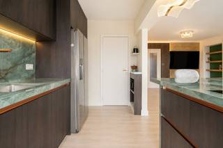 Op de 9de verdieping van een verzorgd residentieel gebouw bevindt zich dit gerenoveerde appartement (105 m² BVO) waar licht, ruimte en comfort centraal staan. Dankzij de hoge ligging geniet u hier elke dag van een indrukwekkend panoramisch uitzicht over de Gentse skyline, terwijl de dubbele terrasoriëntatie zorgt voor zon op elk moment van de dag.De leefruimte baadt in het licht en sluit naadloos aan op de stijlvolle open keuken, die in 2026 volledig werd vernieuwd met hoogwaardige materialen en een eigentijdse afwerking. Het appartement beschikt verder over twee volwaardige slaapkamers, een comfortabele badkamer, een afzonderlijk toilet en een praktische keukenberging. Verder is er nog een privatieve kelderberging.Met terrassen aan beide zijden van het appartement (samen goed voor ca. 15 m²) geniet u zowel van de ochtend- als avondzon en haalt u het buitengevoel volledig naar binnen.Ook op technisch vlak scoort deze eigendom bijzonder sterk. Met een EPC-score van slechts 106 kWh/m²jaar (label B), een energiezuinige warmtepomp, conforme elektriciteit en een asbestveilig attest bent u verzekerd van een toekomstgerichte woonst zonder zorgen.Het appartement is centraal gelegen aan de Martelaarslaan, tussen Gent-Sint-Pieters en het historische stadscentrum. Winkels, horeca, openbaar vervoer en belangrijke invalswegen bevinden zich vlakbij, terwijl u op de 9de verdieping geniet van rust, licht en een uniek uitzicht over de stad.Bestuursmaatregelen in het maatregelenregister: nee