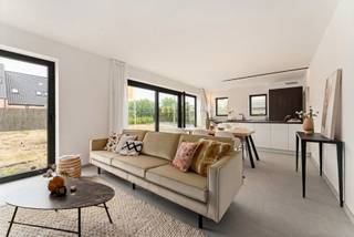 Welkom op onze Inspiratiedag | 31 mei van 10-12 uur

Op een steenworp van het centrum van Vlamertinge verrijst deze moderne woning, gelegen in een rustige woonbuurt op slechts tien minuten van zowel Ieper als Poperinge. Dankzij de centrale ligging zijn winkels, scholen en openbaar vervoer altijd binnen handbereik, wat zorgt voor optimaal wooncomfort.

Bij binnenkomst word je verwelkomd in een uitnodigende inkomhal met gastentoilet. De ruime woon- en eetkamer geniet van overvloedig natuurlijk licht en sluit naadloos aan op de open keuken, wat samen zorgt voor een aangename leefruimte. Aansluitend vind je een praktische berging en een inpandige garage.
Op de eerste verdieping bevinden zich drie comfortabele slaapkamers, een badkamer en een afzonderlijk toilet. De tuin biedt een heerlijke plek om te ontspannen en te genieten van het buitenleven.

Je hebt de vrijheid om de woning volledig naar eigen smaak af te werken. Van de keuken en badkamer tot de vloeren en binnendeuren, jij bepaalt hoe jouw nieuwe thuis eruitziet.

Wil je snel verhuizen naar een energiezuinige nieuwbouw? Dat kan! De woning is reeds afgewerkt tot en met pleisterwerken en chape. Neem contact met ons op en plan jouw bezoekmoment. Wie weet is dit binnenkort jouw nieuwe thuis.