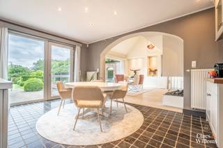 Deze uitzonderlijk ruime villa is rustig gelegen in Itterbeek op een eprceell van +- 19 are, op minder dan 5 minuten van de E40 en met een vlotte verbinding naar Brussel. Dankzij de verhoogde ligging geniet de woning van veel privacy zonder directe inkijk. Bovendien beschikt de villa over een uitstekende energieprestatie met een warmtepomp, centrale verwarming op aardgas, airconditioning, zonnepanelen, een pelletkachel en een gashaard.
Op het gelijkvloers bevinden zich een ruime inkomhal met vestiaire en gastentoilet, een lichtrijke leefruimte met open keuken, een praktische wasplaats met buitendeur, een dubbele garage, een ruime doucheruimte met kleurentherapie en een polyvalente ruimte die kan dienen als slaapkamer, bureau, praktijkruimte of hobbykamer. Dankzij de aparte toegang is deze ruimte ook geschikt voor een vrij beroep of zelfstandige activiteit.
De verdieping omvat een open polyvalente ruimte, een ruime slaapkamer, twee kinderkamers en een mezzanine. Daarnaast beschikt de woning over een afzonderlijke woonvleugel met een tweede leefruimte, een keuken met pelletkachel, een badkamer met bad en douche, een apart toilet, een dressing en een slaapkamer. Deze indeling maakt de woning bijzonder geschikt voor kangoeroewonen, cohousing of inwonende familie.
Op de zolderverdieping bevinden zich een extra mezzanine, momenteel ingericht als fitnessruimte, een zolderruimte en de mogelijkheid om een bijkomende slaapkamer te creëren.
Het terrein is voleldig omheind en afgesloten met een automatische toegangspoort en een afzonderlijk zijpoortje. Er zijn meerdere private parkeerplaatsen, een dubbele garage en een alarmsysteem aanwezig.
De tuin biedt tal van ontspanningsmogelijkheden met een buitenkeuken, een overdekte loungehoek . Daarnaast beschikt het perceel over een afzonderlijk weiland, ideaal voor het houden van dieren.
Troeven
• Rustige ligging nabij E40 en Brussel
• Volledig omheind perceel van ca. 19 are
• Uitstekende energieprestatie
• Warmtepomp, centrale verwarming op aardgas, airconditioning en zonnepanelen
• Pelletkachel en gashaard
• Dubbele garage en meerdere parkeerplaatsen
• Praktijk- of bureauruimte met aparte toegang
• Geschikt voor kangoeroewonen, cohousing of inwonende familie
• Buitenkeuken, jacuzzi en overdekte loungehoek
• Afzonderlijk weiland
• Mogelijkheid tot een bijkomende slaapkamer
Een veelzijdige eigendom met veel woonruimte, privacy en diverse gebruiksmogelijkheden.