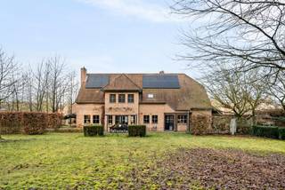 Deze tijdloze villa op een prachtig zuidgericht perceel van +/- 2.750 m² is residentieel gelegen in een doodlopende straat aan de rand van een natuurreservaat. De villa omvat een ruime woonkamer, een bureau, een gezellige leefkeuken, wasplaats, dubbele inpandige garage, 4 slaapkamers, ruime badkamer en zolderverdieping toegankelijk via een vaste trap.<br /><br />Gelijkvloers: <br />Royale inkomhal op natuurstenen vloer met gastentoilet. De woonkamer op massief eiken parket omvat een gezellige zithoek met gashaard en een aansluitende eetkamer. Af te sluiten bureauruimte op parket te bereiken vanuit de woonkamer. De landelijke leefkeuken met ontbijthoek en toegang tot het terras is compleet ingericht met apparatuur (vaatwasser, gaskookplaat, microgolfoven, heteluchtoven). Voorraadberging aanpalend de keuken aanwezig. De praktische wasplaats met zij-inkom is voorzien van ingemaakte kasten, spoelbak en aansluiting voor een wasmachine. De inpandige garage met plaats voor 2 wagens is voorzien van een automatische poort. Alle leefruimtes bieden een mooi uitzicht op de tuin en het achterliggende bosgebied.<br /><br />Verdieping: <br />De natuurstenen trap vanuit de inkomhal brengt ons naar de bovenverdieping. Hier treffen we 4 ruime slaapkamers op parket, waarvan 1 met aanpalende dressing. Deze dressing kan mogelijk omgevormd worden tot 5de slaapkamer. <br />De badkamer is uitgerust met ligbad, douche en dubbele lavabo in een stijlvol meubel. <br /><br />Een vaste trap geeft toegang tot de geisoleerde zolderverdieping. Hier kunnen mogelijk nog extra kamers of hobbyruimten worden gecreëerd.<br /><br />De tuin op het zuiden is rondom zeer verzorgd aangelegd en beschikt over een natuurstenen terras dat paalt aan de leefruimten zoals keuken en woonkamer. Achteraan volledige privacy en geen inkijk van achterliggende buren omwille van aanpalend natuurreservaat. <br /><br />Bijzonderheden: <br />- sublieme ligging in groene residentiele omgeving<br />- gunstige locatie tov Geel - Herentals <br />- kwaliteitsvolle afwerkingsmaterialen<br />- Recent aangelegde voortuin<br />- gunstig EPC - 145 kWh/m² - 16 zonnepanelen, vernieuwde gas HR-ketel, dak en gevel geïsoleerd, zoldervloer en plafond kruipkelder extra na-geïsoleerd