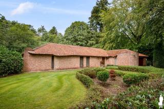 <p><strong>Karaktervolle gelijkvloerse villa op ca. 2.000 m² in zeer rustige, gegeerde en autoluwe wijk Dennendael en dichtbij het natuurgebied</strong></p>
<p>In de <strong>residentiële en bijzonder gegeerde wijk Dennendael</strong> bevindt zich deze karaktervolle gelijkvloerse villa op een royaal perceel van circa <strong>2.000 m²</strong>. De brede architectuur, royale leefruimtes en grote raampartijen creëren een aangenaam gevoel van ruimte en licht, terwijl de volwassen groene omkadering zorgt voor rust en privacy.<br />Met <strong>4 slaapkamers, 2 badkamers, een ruime master suite, dubbele inpandige garage en aangelegde tuin</strong> biedt de woning bovendien een volledig gelijkvloers woonprogramma.</p>
<p><strong>Gelijkvloerse verdieping<br /></strong>- Lichtrijke <strong>inkomhal</strong> met mooie doorkijken naar de woonvertrekken<br />- Gastentoilet<br />- Royale <strong>woon- en eetkamer</strong> met grote raampartijen en zicht op de tuin<br />- Sfeervolle zithoek met <strong>houthaard</strong> en karaktervolle houten balkenstructuur<br />- Groot schuifraam met rechtstreekse toegang tot terras en tuin<br />- Afzonderlijke keuken met <strong>granieten werkblad</strong>, ontbijthoek<br />- Ook vanuit de keuken rechtstreekse toegang tot de tuin<br />- <strong>4 volwaardige slaapkamers </strong>waarvan 1<strong> </strong>master bedroom met ruime <strong>dressing met maatkasten</strong> en ensuite badkamer met <strong>ligbad, inloopdouche en dubbel lavabomeubel<br /></strong>- Tweede badkamer met <strong>douche, lavabo en toilet<br /></strong>- Praktische wasruimte met uitgietbak en deur naar de tuin<br />- Natuurstenen vloer in de leefruimtes en parket in 3 slaapkamers<br />- <strong>Volledige vloerverwarming</strong></p>
<p><strong>Kelder en zolder<br /></strong>- Praktische kelderruimte, ideaal als voorraadruimte met plaats voor extra koelkast en diepvriezer<br />- Overige gedeelte voorzien van kruipruimte<br />- B<strong>ergzolder</strong>, toegankelijk via de garage</p>
<p><strong>Garage en berging<br /></strong>- <strong>Dubbele inpandige garage</strong> met sectionaalpoort<br />- Twee bergingen, waarvan één met toegang naar buiten</p>
<p><strong>Tuin en buitenruimte<br /></strong>- Royaal perceel <strong><br /></strong>- <strong>Aangelegde en zonnige tuin</strong> omgeven door volwassen groen<br />- Veel <strong>rust en privacy<br /></strong>- Ruim terras aansluitend op leefruimte en keuken<br />- Afzonderlijke <strong>overdekte zithoek met openhaard<br /></strong>- Buitenverlichting en meerdere waterpunten<br />- Ruime oprit met parkeergelegenheid voor meerdere wagens</p>
<p><strong>Bijzonderheden<br /></strong>- Verkeersluwe straat met uitsluitend bewonersverkeer in een rustige buurt <br />- <strong>Gegeerde residentiële ligging in Dennendael<br /></strong>- Volledig <strong>gelijkvloers woonprogramma<br /></strong>- <strong>4 slaapkamers en 2 badkamers </strong>waarvan 1 master suite met dressing en ensuite badkamer<br />- Grote glaspartijen en sterke verbinding met de tuin<br />- <strong>Dubbele inpandige garage<br /></strong>- Volledige vloerverwarming op aardgas<br />- Recente hoogrendementsketel<br />- Houten ramen met dubbele beglazing en vliegenramen<br />- Geïsoleerd dak<br />- Natuurgebied op 150 meter</p>
<p><strong>Ligging<br /></strong>Gelegen <strong>in Heide</strong>, midden in de residentiële wijk <strong>Dennendael</strong>. Ruime percelen, volwassen bomen en de nabijheid van het <strong>militair domein en uitgestrekte groenzones</strong> zorgen voor een bijzonder rustige en groene woonomgeving. Het centrum van Heide en de dagelijkse voorzieningen zoals scholen, winkels en station zijn zeer dichtbij.</p>
<p><strong>Een karaktervolle gelijkvloerse villa waar royale woonvolumes, 4 slaapkamers en een prachtig groen perceel samenkomen op een discrete en gegeerde locatie in Dennendael.</strong></p>
<p>Bewoonbare opp. 209 (exclusief garage 35m) m² ref.: bruto vloeropp. EPC-certificaat.</p>
<p></p>