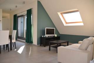 <p>Energiezuinig instapklaar dakappartement op de derde verdieping van een uitstekend onderhouden gebouw biedt een perfecte balans tussen comfort, energiezuinigheid en een centrale ligging. U bereikt de woning gedeeltelijk via de lift en komt binnen in een sfeervolle, open leefruimte. Dankzij de royale oppervlakte kan deze kamer naar eigen smaak worden onderverdeeld in een gezellige zithoek en een ruime eetkamer. Een praktische extra hier is de eerste, ruime berging die discreet in de woonruimte is geïntegreerd.</p>
<p>De leefruimte loopt naadloos over in de volledig ingerichte open keuken, uitgerust met kwaliteitsvolle toestellen. Direct tegenover de keuken bevindt zich de toegang tot het zonnige terras, ideaal om buiten te tafelen of te ontspannen.</p>
<p>Via een kleine nachthal bereikt u de overige ruimtes: namelijk een gastentoilet met handenwasser, een tweede, functionele berging met aansluitingen voor wasmachine en droogkast alsook de slaapkamer met directe toegang tot de aangrenzende badkamer, voorzien van een douche en wasmeubel.</p>
<p>Als grote troef beschikt het appartement over een private, overdekte staanplaats in de afgesloten ondergrondse parkeergarage. Hierdoor bent u altijd verzekerd van een veilige parkeerplek in het centrum. Met een uitstekende EPC-score en een lage maandelijkse vaste kost van slechts € 40,-, geniet u hier van zorgeloos wonen op wandelafstand van winkels, horeca en het openbaar vervoer.</p>