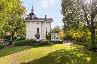 <h1><span>Karaktervolle villa met torentje en ruime tuin in Kapellen</span></h1>
<p><span>In de Eikendreef in Kapellen bevindt zich deze karaktervolle woning uit 1880. De villa ligt in een rustige, groene omgeving en onderscheidt zich door haar typische architectuur, met een torentje, geschilderde bakstenen gevels en karakteristieke dakpartijen.</span></p>
<p><span>De woning werd opgetrokken in cottagestijl, een bouwstijl die herkenbaar is aan de combinatie van verschillende dakvormen en decoratieve details. Het torentje geeft de woning een eigen uitstraling. Ook de gevels en de overige architecturale elementen verwijzen naar de bouwstijl van die periode.</span></p>
<p><span>Binnen beschikt de woning over vijf slaapkamers en twee badkamers. De verschillende ruimtes bieden mogelijkheden voor een gezin dat op zoek is naar een woning met karakter en voldoende plaats. Afhankelijk van de wensen van de toekomstige eigenaar kan de indeling verder worden aangepast. De woning is opgenomen als bouwkundig erfgoed. Afhankelijk van het toepasselijke erfgoedstatuut en de wettelijke voorwaarden kan een vrijstelling van de Vlaamse renovatieverplichting gelden.</span></p>
<p><span>De woning beschikt over een ruime tuin die volop mogelijkheden biedt om buiten te genieten. De groene omgeving en de rustige ligging maken dit tot een aangename plek om te wonen.</span></p>
<p><span>Achteraan op het perceel bevindt zich bovendien een afzonderlijke conciërgewoning van ca. 120 m², met een ruime garage. Het gebouw dient te worden gerenoveerd, maar biedt verschillende mogelijkheden, zoals een kangoeroewoning, gastenverblijf, kantoor of praktijkruimte.</span></p>
<p><span>Een woning met een eigen bouwkundige uitstraling, een ruime tuin en een bijkomend gebouw dat mogelijkheden biedt voor wie op zoek is naar extra ruimte.</span></p>