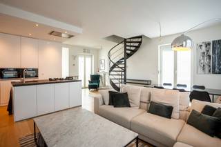 <p>Hoogwaardig afgewerkt en prachtig gemeubelde duplexpenthouse van ca 125 m² op de vierde en vijfde verdieping van een kleinschalige realisatie. <br /><br />Het appartement bevindt zich op een toplocatie, pal in de Riemstraat op het bruisende Zuid. De Kloosterstraat, Scheldekaaien en nieuwe Zuidpark bevinden zich op wandelafstand, alsook tal van restaurants, winkels en supermarkten.<br /><br />De leefruimte op parket kan genieten van een optimale lichtinval dankzij de grote raampartijen. De smaakvolle designkeuken met kookeiland is volledig uitgerust met uiterst kwalitatieve toestellen: gasvuur, koelkast, diepvries, wijnkoeler, vaatwasser, stoomoven en aparte heteluchtoven. Het werkblad in granietsteen maakt het geheel af.<br /><br />De leefruimte geeft toegang tot twee prachtige terrassen van samen ca 35 m².<br /><br />De ruime masterbedroom bevindt zich aan de rustige achterzijde en is voorzien van ingemaakte dressingkasten. Deze werd afgesloten van de leefruimte via een stijlvolle smeedijzeren deur en kan gebruikmaken van een badkamer met inloopregendouche en lavabomeubel.<br /><br />Eyecatcher in de leefruimte is de wenteltrap die toegang geeft tot de bovengelegen verdieping. Hier bevinden zich nog twee ruime slaapkamers. Deze delen een tweede badkamer met bad/douche combinatie, lavabo en toilet.<br /><br />Een praktische berging is voorzien van aansluitingen voor wasmachine en droogkast. Apart gastentoilet.<br /><br />Een dubbele cascade autostaanplaats (voor 2 wagens achter elkaar) en een kelderberging zijn reeds begrepen in de huurprijs.<br /><br />Gemeenschappelijke lasten: 120 Euro per maand.<br />Alle nutsvoorzieningen (gas, water en elektriciteit) zijn privé op te nemen door de huurder.<br /><br />Beschikbaar vanaf 1 juni 2026</p>