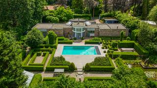 Vous êtes à la recherche d’une villa d’architecte unique où le calme, l’intimité et le confort occupent une place centrale ? Cette exceptionnelle villa de plain-pied, conçue par l’architecte Michel Grandsard, saura sans aucun doute vous séduire.
Située dans le très prisé quartier résidentiel de Kapellenbos, cette propriété de caractère est implantée sur un magnifique terrain de 2.038 m². Elle allie une architecture intemporelle à un jardin exceptionnel et offre une qualité de vie rare dans un environnement verdoyant et résidentiel.
Dès l’entrée, vous découvrez un vaste hall avec vestiaire et toilette invités menant à un lumineux espace de vie agrémenté d’un chaleureux feu ouvert. Les grandes baies vitrées offrent une vue imprenable sur le jardin paysager. La salle à manger s’intègre harmonieusement à la cuisine fonctionnelle.
La maison dispose actuellement de deux spacieuses chambres avec la possibilité d’aménager facilement une troisième chambre ou un espace bureau.
À l’extérieur, vous profitez d’un magnifique jardin arboré avec étang d’agrément, piscine et plusieurs terrasses où vous pourrez vous détendre en toute tranquillité. Grâce à la clôture complète et au portail automatique, vous bénéficiez d’une intimité et d’une sécurité optimales.
La propriété comprend également un garage intégré, une cave à vin aménagée ainsi que plusieurs emplacements de parking privatifs.
PEB : label E – obligation de rénovation applicable.
Une opportunité rare pour les amateurs d’un cadre de vie exclusif dans l’un des quartiers résidentiels les plus recherchés de Kapellen.
Intéressé(e) ? Contactez Immo LEY au 03 535 20 00 ou par e-mail à info@immoley.be pour plus d’informations ou pour organiser une visite.