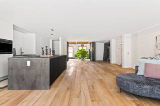 Dit stijlvolle en bijzonder ruime appartement/loft van ca. 190 m² bevindt zich op een absolute toplocatie in het hart van Schoten, met prachtig zicht op het Marktplein en het Gemeentehuis. Een unieke combinatie van ruimte, licht, comfort en een centrale ligging.<br /><br />De royale leefruimte vormt het hart van de woning en geniet dankzij de grote raampartijen van een overvloed aan natuurlijk licht. De open en luchtige sfeer wordt versterkt door het ruime inpandige terras, een bijzondere meerwaarde waar u het hele jaar door in alle rust kunt genieten.<br /><br />De huidige indeling omvat een ruime slaapkamer met een luxueuze badkamer. Dankzij de vele ingemaakte kasten is er bovendien voldoende ruimte voor een dressing en extra bergruimte. <br /><br />De volledig nieuw geïnstalleerde open keuken sluit naadloos aan bij de leefruimte en is uitgerust met alle nodige toestellen. De hedendaagse inrichting en kwalitatieve afwerking maken van deze woning een comfortabele en stijlvolle thuis.<br /><br />Een belangrijke troef is de mogelijkheid om de woonruimte nog verder uit te breiden. De aansluitende ruimte wordt momenteel gebruikt als kantoor, maar kan mits de nodige aanpassingen worden ingericht als twee extra slaapkamers en een bijkomende badkamer. Hierdoor zijn er tal van mogelijkheden voor gezinnen, thuiswerkers of wie extra leefruimte wenst.<br /><br />Daarnaast beschikt het appartement over een ruime kelder, ideaal als extra opslagruimte.<br /><br />De centrale ligging is bijzonder praktisch: winkels, horeca, openbaar vervoer en diverse andere voorzieningen bevinden zich allemaal op wandelafstand. U woont hier midden in het centrum, met alles binnen handbereik.<br /><br />Kortom: een uitzonderlijk ruim en lichtrijk appartement/loft met inpandig terras, hoogwaardige leefkwaliteit en interessante uitbreidingsmogelijkheden, gelegen op een toplocatie in het centrum van Schoten.<br /><br />Naast de foto's geven renders een beeld weer van de mogelijkheden van dit appartement.<br /><br />Gemeenschappelijke kosten: €145.