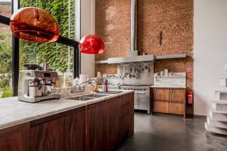 Deze eigenzinnige woning is ontstaan uit een herenhuis, versmolten met een nieuwbouwwoning. U geniet dus van de prachtige stijl van een herenhuis in het comfort en ruimtelijkheid van een nieuwbouw, met grote glaspartijen, veel lichtinval en een zeer ruime tuin. <br /><br />U komt binnen via de oude woning met prachtige authentieke elementen en geniet onmiddellijk van het comfort van de nieuwbouwwoning met zeer hoge plafonds en een grote raampartij die rechtstreeks uitkomt op de tuin. De breedte van de tuin is 11 meter, ingericht in Piet Oudolfstijl, waardoor je midden in de stad kan genieten van een eigentijdse oase van groen. <br /><br />Omdat de woning meer dan 500m² omvat beschikt u over een grote leefruimte met geïnstalleerde keuken, aangrenzend aan de tuin. Via zwevende betonnen treden komt u in de living. In dit (nieuwbouw) gedeelte van de woning vindt u ook nog drie slaapkamers en een badkamer en dressing. Naast de keuken bevindt zich een grote garage (40m²). Als je in de inkomhal de trap omhoog neemt, komt u in een apart gedeelte van de woning met nog eens vier slaapkamers, twee badkamers, een leefruimte met keuken en een dakterras met prachtig zicht op de stad, dit gedeelte staat volledig los van de andere delen van de woning en wordt momenteel in co-housing gebruikt. De woning is ontworpen door de architecten 'Verdickt &amp; Verdickt '.Ideaal als praktijk of kantoorruimte. <br /><br />De omgeving van de Oude Steenweg bevindt zich in een stukje Antwerpen in volle ontwikkeling, vlakbij de Paardenmarkt via waar je op wandelafstand bent van zowel het toeristische centrum als het bruisende Eilandje. De wijk Dam met park Spoor Noord en de vernieuwde slachthuissite bevindt zich ook op wandelafstand. Aan de woning zelf zijn er volop winkels en openbaar vervoer.