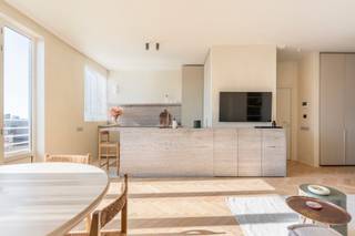 <p>Op de achtste verdieping van een verzorgd gebouw bevindt zich deze exclusieve penthouse, ontworpen door interieurarchitect Britt Van Namen. Een uitzonderlijke woonervaring met panoramisch zicht over de Antwerpse skyline, waar onder meer de Kathedraal en het MAS het decor vormen.</p>
<p>De VME voorziet binnenkort belangrijke renovatiewerken (dakisolatie, vernieuwing terrassen en borstweringen, modernisering stookplaats), wat zal resulteren in een aanzienlijke verbetering van het EPC naar een geschat A- of B-label.</p>
<p>De op maat gemaakte keuken vormt het kloppend hart van het appartement en werd afgewerkt met hoogwaardige materialen zoals een travertin werkblad en een Novy Panorama kookplaat. Aansluitend bevindt zich de lichtrijke leefruimte op visgraatparket, die naadloos overgaat in het zuidgerichte terras met open en weids uitzicht.</p>
<p>De penthouse beschikt over twee slaapkamers, beide voorzien van ingemaakte kasten. De hoofdslaapkamer werd uitgewerkt als een stijlvolle suite met designbad, een op maat gemaakt beddenhoofd met geïntegreerde ledverlichting en een ensuite badkamer met microtopping inloopdouche en dubbele wastafel.</p>
<p>Doorheen het volledige appartement zorgen hoogwaardige materialen, verfijnde afwerkingstechnieken en doordacht maatwerk voor een tijdloze en luxueuze uitstraling.</p>
<p><strong>Extra troeven:</strong></p>
<ul>
<li>Vestiaire en aparte berging met aansluiting voor wasmachine en droogkast</li>
<li>Mogelijkheid tot overname huurcontract van een autostaanplaats</li>
<li>Conforme elektriciteit</li>
<li>EPC opgesteld vóór de renovatiewerken</li>
<li>Maandelijkse lasten inclusief water en provisie verwarming</li>
</ul>
<p>Verplichte aankoop van een kelderberging (€5.000) en overname van geselecteerde meubels en verlichting (€35.000).</p>
<p>Contacteer LISTED voor een bezoek: +32 3 283 51 51.</p>