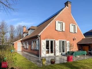 Sfeervolle woonst bestaande uit een inkomhall, living met open haard, keuken met eetruimte, wasberging, 3 slaapkamers, badkamer, kelder, garage en zuidgerichte tuin