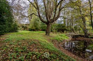 Deze karaktervolle neoclassicistische herenwoning uit 1868 deed dienst als brouwerswoning van de brouwerij Du Bois-Haems.<br /><br />Via de voormalige koetsdoorgang komt men uit op een prachtige binnenkoer die toegang biedt tot de vroegere paardenstallen. Daarnaast zijn er twee garageplaatsen voorzien. De grootste troef van het pand is de enorme parktuin met vijver en antiek zwembad dat achter het pand verscholen zit. Zodra u de grote toegangspoort sluit kunt u heerlijk genieten van natuur en rust, doch is de woning centrum-gelegen. <br /><br />Unieke leefruimte met talloze decoratieve elementen, 3 open haarden en grote leefkeuken met AGA -fornuis. De decoratieve elementen bevinden zich in goede staat en zetten de authenticiteit kracht bij. Verder is er op de gelijkvloerse verdieping een royale inkomhal met toegang tot een ruime eetruimte. Dit laatste kan ook gebruikt worden als bureauruimte.<br /><br />Op de eerste verdieping bevinden er zich 7 slaapkamers en 2 recent gerenoveerde badkamers. Ook hier werden authentieke elementen gebruikt vol charme. Tot slot beschikt de woning over een zeer ruime zolder dat verschillende bestemmingen kan innemen. <br /><br />Gezien uitstraling, de ligging in het centrum van Lebbeke, de grootte van het perceel en de ruime bruikbare vloeroppervlakte, biedt dit beschermd monument zéér veel mogelijkheden.