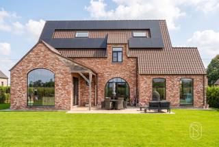Exclusieve nieuwbouwwoning met 5 slaapkamers, 360 m² woonoppervlakte, toekomstgerichte voorzieningen, en genietend van een prachtig zicht! Bent u op zoek naar een uitzonderlijk ruime en kwalitatieve woning waar comfort, luxe en toekomstgericht wonen centraal staan? Deze in 2023 gebouwde woning biedt maar liefst 360 m² bewoonbare oppervlakte op een perceel van 1.235 m² en werd technisch bijzonder doordacht uitgevoerd.Indeling gelijkvloers: ruime inkomhal, afzonderlijke ruimte ideaal als bureau, apart toilet en een zeer ruime, lichtrijke leefruimte. Aansluitend bevindt zich de luxueuze, volledig geïnstalleerde keuken met hoogwaardige Miele-toestellen, waaronder wijnkoeler, stoomoven, oven, vaatwasser en espressomachine. Verder is er een grote wasruimte met douche en waskoker vanuit de badkamer boven. De inpandige garage biedt plaats aan één wagen, technische installaties en extra stockage.Eerste verdieping: vier slaapkamers, apart toilet en een royale ruimte voorzien voor de inrichting van een wellnessbadkamer, nog volledig af te werken volgens eigen smaak en materiaalkeuze.Zolderverdieping: ingerichte vijfde slaapkamer met verdere afwerkingsmogelijkheden. De voorziene liftschacht loopt door tot deze verdieping.Technisch is de woning bijzonder compleet met vloerverwarming op het gelijkvloers en de eerste verdieping, ventilatiesysteem type D, brede deuropeningen en een liftschacht met bekabeling voor de plaatsing van een inpandige lift.Buiten geniet u van een ruim terras, tuin en meerdere parkeerplaatsen. Bovendien is er een vergunning voor een bijgebouw van 14 m².Een aantal ruimtes dienen nog naar eigen smaak worden afgewerkt, waardoor u zelf de gewenste materialen en inrichting kunt bepalen.Voor wie is dit pand ideaal?♦ Gezinnen die uitzonderlijk veel woonruimte zoeken.♦ Wie comfortabel én toekomstgericht wil wonen.♦ Wie een recente woning verder naar eigen smaak wil afwerken.Een unieke kans voor wie ruimte, kwaliteit en toekomstgericht wooncomfort wil combineren.Bezoek na afspraak met Immo Beguin, jouw vastgoedexpert sinds 2009.Meer info of bezoek via emmy@immobeguin.be