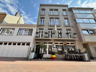 Ontdek dit centraal gelegen HOTEL met CAFÉ & PRIVÉ APPARTEMENT op slechts enkele stappen van de zeedijk, de minigolf & de sfeervolle jachthaven van Blankenberge. Deze zaak combineert een toeristische topligging met uitstekende commerciële mogelijkheden. Het hotel beschikt over 9 ruime gastenkamers, elk voorzien van een eigen badkamer. Op het gelijkvloers bevindt zich een gezellig caféetje toegankelijk voor zowel hotelgasten als bezoekers van buitenaf. Daarnaast is er het onthaal, toiletten, een aparte ontbijtzaal, een uitgeruste keuken met aanpalend een ruime berging. Een extra troef is het privé appartement op de eerste verdieping. Deze woonunit bestaat uit een leefruimte, keuken, badkamer en twee slaapkamers. Het appartement is momenteel verhuurd. Op deze verdieping bevinden zich bovendien nog twee gastenkamers. De tweede en derde verdieping huisvesten de overige gastenkamers. Onder het dak is er nog een ingerichte, ruime zolderkamer die perfect dienst kan doen als extra privéruimte. Het gebouw is voorzien van een LIFT en beschikt tevens over een kelder. Met zijn uitstekende ligging nabij zee, jachthaven en station, is dit pand een unieke kans voor wie wil investeren in een bruisende badstad.