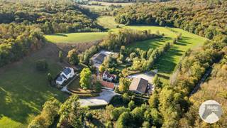 <p>EERSTE BEZOEKDAG ZATERDAG 31/10 VANAF 8U tot 12U (enkel op afspraak!)<br /><br />CHIMAY – Uitzonderlijk toeristisch domein van ca. 10ha met meerdere gîtes en manoirs<br /><br />Gelegen in het groene en landelijke landschap van Chimay, bevindt zich dit bijzondere toeristische domein, bestaande uit meerdere karaktervolle verblijven, twee grote loodsen en een stal, te midden van een uitgestrekt domein van circa 10 hectare.<br />De eigendom combineert de charme van historische gebouwen met de mogelijkheden van een veelzijdige toeristische exploitatie. De gebouwen werden in 1992 verbouwd en bieden vandaag onderdak aan verschillende vakantieverblijven met uiteenlopende capaciteiten, waardoor zowel kleinere gezelschappen als grote groepen ontvangen kunnen worden.<br /><br />Het domein bestaat uit verschillende afzonderlijke accommodaties, elk met hun eigen karakter en mogelijkheden:<br />• Le Manoir: ruime groepsaccommodatie met een capaciteit tot 35 personen.<br />• Le Petit Manoir: karaktervol verblijf voor groepen tot 8 personen.<br />• Gîte voor 10 personen: ideaal voor families en grotere gezelschappen.<br />• Twee gîtes voor 2 personen: perfect voor koppels of kleinere gezelschappen.<br />• Een bijkomende gîte: momenteel ingericht voor privégebruik.<br /><br />Dankzij deze combinatie beschikt het domein over een gevarieerd verhuuraanbod. <br />De circa 10ha grond zorgen voor een uitzonderlijk ruim en groen kader, waar rust, privacy en natuur centraal staan.<br />Naast de verschillende verblijven omvat het domein ook twee grote loodsen en een stal. Deze bijkomende gebouwen bieden extra mogelijkheden voor opslag, dieren, …<br />De landelijke ligging in de streek van Chimay vormt bovendien een aantrekkelijke uitvalsbasis voor bezoekers die willen genieten van natuur, wandelen, fietsen en de toeristische troeven van de regio.<br /><br />Een bijzonder belangrijk pluspunt is dat de roerende goederen grotendeels in de verkoop zijn inbegrepen, met enkele uitzonderingen.<br />Hierdoor kan een nieuwe eigenaar beschikken over een reeds ingerichte accommodatie en wordt de drempel om de toeristische activiteit opnieuw op te starten aanzienlijk verlaagd. <br /><br />Een uitzonderlijke opportuniteit in Chimay voor wie ruimte, karakter en toeristisch potentieel wil combineren in één veelzijdig geheel.<br /><br />Interesse in dit bijzondere domein? Contacteer ons voor meer informatie of een bezoek ter plaatse: 053/60.65.66.</p>