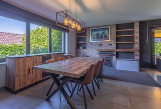 <p>Deze ruime villa met 4 slaapkamers bevindt zich in een residentiële en groene omgeving in Dilbeek, op een mooi perceel van 18a29. De woning onderging in 2015 verschillende renovaties en bevindt zich vandaag in degelijke en verzorgde staat, ideaal voor wie op zoek is naar ruimte, privacy en een combinatie van wonen en werken.</p><p>Via de inkomhal met gastentoilet en vestiaireruimte kom je terecht in de aangename leefruimte met veel natuurlijk licht. De vernieuwde en volledig ingerichte keuken sluit hier mooi op aan en biedt een prachtig zicht op de groene tuin. Dankzij de rustige ligging en de volwassen beplanting geniet je hier van veel privacy en een aangename woonomgeving.</p><p>Op het gelijkvloers bevindt zich daarnaast een praktische bureauruimte en een slaapkamer met douche, wat deze woning ook geschikt maakt voor gelijkvloers wonen of een multifunctionele invulling.</p><p>Een belangrijke troef van deze villa in Dilbeek is de afzonderlijke ingang naar de praktijkruimte. Deze ruimte is momenteel ingericht als schoonheidssalon en beschikt over een wachtruimte en een apart toilet. Ideaal voor een vrij beroep, zelfstandige activiteit of praktijk aan huis.</p><p>Op de eerste verdieping bevinden zich 3 ruime slaapkamers, elk uitgerust met een airco-installatie. Verder zijn er 2 badkamers, een afzonderlijk toilet en een extra zolderkamer die perfect dienst kan doen als hobbyruimte, dressing of extra bergruimte.</p><p>De woning is deels onderkelderd en beschikt over een ruime inpandige garage met voldoende opslagmogelijkheden. Voor de woning is er bovendien ruime parkeergelegenheid voorzien.</p><p>Deze villa combineert een groene en residentiële ligging met een praktische indeling en veel mogelijkheden voor grote gezinnen of zelfstandigen. Dankzij het EPC D en de conforme elektrische keuring geniet je bovendien van extra comfort en gemoedsrust. Ontdek zelf de ruimte, het licht en de rustige omgeving tijdens een bezoek.</p>