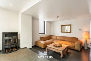 Voor meer info en foto’s, surf naar www.swevers.be – In de Lochtstraat in Bilzen-Hoeselt bevindt zich deze verrassend ruime woning met een warme uitstraling en een praktische indeling. De woning werd oorspronkelijk gebouwd tussen 1900 en 1918 en onderging in 2013 een totaalrenovatie, waardoor karakter en hedendaags comfort hier mooi samenkomen. Met een bewoonbare oppervlakte van 192 m², verdeeld over drie niveaus, biedt deze woning tal van mogelijkheden voor gezinnen, thuiswerkers of wie gewoon graag ruim woont. Op het gelijkvloers geniet u van een gezellige leefruimte van 20 m² en een bijzonder ruime keuken van 44 m² met voldoende plaats voor een grote eettafel. Verder vindt u hier nog een apart bureau, ideaal als thuiswerkplek, hobbyruimte of gelijkvloerse slaapkamer. Vloerverwarming zorgt voor extra dagelijks comfort. De eerste verdieping beschikt over een ruime slaapkamer van 21 m² en een praktische badkamer. Op de tweede verdieping bevinden zich nog twee extra slaapkamers van respectievelijk 19 m² en 17 m², perfect als kinder-, logeer- of hobbykamer. Buiten geniet u van een gezellige tuin met voldoende privacy op een onderhoudsvriendelijk perceel van 2a 53ca. Daarnaast is er een garage aanwezig voor één wagen met extra bergruimte. De ligging vormt een extra troef dankzij de vlotte verbinding naar omliggende gemeenten en de autosnelweg op slechts 5,6 km. Scholen, openbaar vervoer, winkels en ontspanning bevinden zich eveneens vlakbij. Voor meer informatie, bel 012 699 900. Bron bewoonbare oppervlakte: EPC – verslag.
