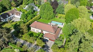 Gelegen in een uiterst rustige laan in het prestigieuze Domein van Bouchout te Wemmel, biedt deze groots opgezette villa hypermodern wooncomfort waar licht en ruimte centraal staan. De strategische ligging garandeert een serene, veilige leefomgeving nabij scholen, invalswegen en de Brusselse Ring.De indrukwekkende inkomhal leidt naar een royaal salon met design-gashaard en plafondhoge ramen, grenzend aan een formele eetkamer. De exclusieve eiken leefkeuken met granieten werkblad is voorzien van een centraal kookeiland, massief houten ontbijtbar en premium inbouwapparatuur (o.a. een rvs Amerikaanse koelkast en stoomoven). Grote schuiframen bieden toegang tot het terras. Aansluitend bevindt zich een praktische wasplaats/bijkeuken die doorsteekt naar de dubbele inpandige garage.Op de eerste verdieping biedt de nachthal toegang tot vier royale slaapkamers. De master suite beschikt over een maatwerk dressing en een luxe badkamer in travertijn natuursteen met ligbad. De overige drie slaapkamers zijn uitgerust met inbouwkasten en worden geflankeerd door twee moderne douchekamers. Een grote, geïsoleerde zolder biedt extra uitbreidingsmogelijkheden.De volledig omsloten loungetuin biedt 100% privacy dankzij de hagen. Centraal ligt het grote, verwarmde buitenzwembad (warmtepomp), omringd door een hardhouten terras en diverse zithoeken. Het perfect georiënteerde terras achteraan biedt een prachtig panorama over het volledige domein.Droomt u ook al weg? Neem dan snel contact op!Bestuursmaatregelen in het maatregelenregister: nee