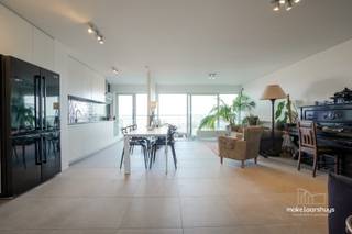 U kan zich inschrijven voor de bezoekmomenten via de website.<br /><br />Dit stijlvol, modern afgewerkt en instapklaar appartement van 99m2, baadt dankzij de dubbele oriëntatie de hele dag in het licht. U geniet aan beide zijden van een eigen terras met vergezicht. Een doordachte indeling scheidt de leefruimte, via een ruime doorloop, van de slaapkamer. <br /><br />De living met eethoek vormt het hart van de woning. Via brede schuiframen stapt u het terras op, waar de glazen balustrade het zicht vrijhoudt: dé plek voor een zondagsontbijt of een aperitief terwijl de stad onder u oplicht. De open keuken met inbouwoven, kookplaat en een kamerhoge kastwand met nis voor een Amerikaanse koelkast biedt bergruimte in overvloed, in combinatie met een prachtig uitzicht. <br /><br />Aan de andere zijde ligt een royale, lichtrijke slaapkamer met o.a. ingemaakte kasten, plaats voor een bureau- of leeshoek en rechtstreekse toegang tot het tweede terras. Hier wordt u wakker met een zicht op de andere kant van Gent. De ruim opgevatte badkamer beschikt over een inloopdouche, een lavabo en een zwevend toilet. Bovendien is het appartement volledig rolstoeltoegankelijk, wat comfortabel wonen garandeert voor vandaag én later.<br /><br />Ten slotte biedt een afgesloten garagebox plaats aan uw wagen, fietsen of extra spullen en maakt het plaatje compleet.<br /><br />Licht, ruimte, privacy en een uitzicht dat nooit verveelt, met het bruisende stadsleven binnen handbereik.