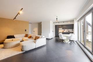 Op zoek naar een instapklaar appartement met veel lichtinval én uitzonderlijk veel buitenruimte? Dit moderne appartement combineert comfort, ruimte en een uitstekende ligging in het centrum van Wachtebeke. Winkels, horeca en ontspanningsmogelijkheden bevinden zich op wandelafstand.Het appartement bevindt zich op de tweede verdieping en is bereikbaar via lift of trap. Vanuit de inkomhal bereikt u de ruime en lichtrijke leefruimte, waar de grote raampartijen en hoge plafonds zorgen voor een aangenaam ruimtegevoel. Vanuit de leefruimte heeft u toegang tot een eerste terras.Aansluitend bevindt zich de moderne keuken gecombineerd met een praktische berging. Verder beschikt het appartement over twee ruime slaapkamers, die beide toegang bieden tot een tweede terras. Eén slaapkamer beschikt bovendien over een eigen douche. Airconditioning is aanwezig.De badkamer is uitgerust met een inloopdouche, dubbele lavabo en toilet.De absolute troef is het ruime zonneterras, dat rechtstreeks vanuit de leefruimte bereikbaar is via een trap. Dit is de ideale plek om te genieten van zonnige dagen.Troeven:• 3 terrassen• Ruime en lichtrijke leefruimte• Groot zonneterras• 2 ruime slaapkamers• 2 badkamers/doucheruimtes• Moderne keuken met ingebouwde toestellen• Airconditioning• Energiezuinig en instapklaar• Lift aanwezig• Ondergrondse staanplaats inbegrepen• Centrum WachtebekeInteresse? Contacteer Kasper Maes via 0470 50 98 57 of kasper.maes@immo-zone.be.