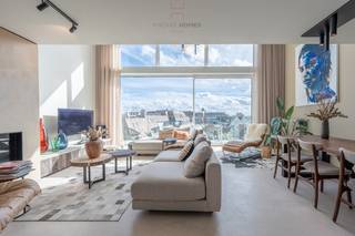 Magnifique mezzanine d'environ 215 m2 et d'une largeur de 6m80 dans la nouvelle résidence Hampton Beach, très bien située dans l'avenue des Anglais à proximité de la digue et du club de voile RBSC de Duinbergen.<br /><br />Aménagement au sixième étage : entrée avec toilettes pour invités, vestiaire et débarras. Espace de vie spacieux et avec une belle largeur, foyer au gaz ambiant, exceptionnellement éclairé par les grandes fenêtres de la mezzanine, s'ouvrant sur la terrasse orientée au sud avec une vue dégagée sur les villas. À l'arrière se trouve la grande cuisine ouverte équipée avec îlot centrale (plan de travail en pierre naturelle), une arrière cuisine et accès à la terrasse arrière.<br /><br />Au septième étage se trouvent les trois chambres spacieuses. La chambre principale avec salle de douche attenante, la chambre double des invités et la mezzanine verrouillable par une porte coulissante et équipée d'un dressing ouvert et d'une salle de douche séparée où il y a également un raccordement pour WM/DK. Dans le hall de nuit se trouve une troisième salle de bain, équipée d'une baignoire, de toilettes et d'un lavabo. Le septième étage est également accessible par l'ascenseur commun.<br /><br />La finition de cet appartement est de très haute qualité et les matériaux utilisés ont été soigneusement choisis pour s'intégrer parfaitement à l'intérieur exceptionnel. Par exemple, toutes les armoires sur mesure ont été fabriquées en bois de grange et le sol du salon a été recouvert d'un enduit à la chaux. La même finition a été poursuivie sur les escaliers menant à la mezzanine, de sorte que tout se fond dans un ensemble harmonieux qui apporte lumière et tranquillité. Le choix du verre solaire côté sud et des stores électriques a également été délibéré. L'étage supérieur est équipé de parquet et les salles de bains sont meublées en noyer et en chêne brut.<br /><br />Techniquement, ce bel appartement est équipé d'installations modernes et économes en énergie : des compteurs individuels (eau, gaz et électricité), un système de ventilation de type D avec système de gaines intégrées et une chaudière murale à gaz à condensation, commodément stockée dans le local technique. L'appartement est également équipé de l'air conditionné, contrôlable séparément par pièce.<br /><br />Une cave privée avec des crochets pour vélos appartient à cet appartement supérieur et il y a la possibilité d'acheter un garage box double (via l'ascenseur à voitures) dans l'immeuble. Contactez-nous au 050/760.760 pour toutes les informations et une visite sans engagement.