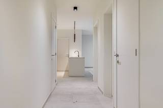 Deze nieuwbouwappartementen zijn voorzien van alle modern comfort, energie neutraal en knappe architectuur. De indeling van het 1eV  appartement, achteraan gelegen (ca 100,27m2 bew opp) is als volgt: inkomhal met gastentoilet, aangename en zeer lichtrijke leefruimte met open keuken grenzend aan het overdekte zonneterras van ca 11,82m2), aparte berging/wasplaats, 2 ruime slaapkamers aanwezig. extra's: ruime fietsenstalling en vuilnisberging voorzien, alles volledig geschilderd+verlichting, inclusief privatieve zonnepanelen, warmtepomp, lage gemeenschappelijke kosten (geen lift). Dit project valt onder 6% BTW (mits voorwaarden).