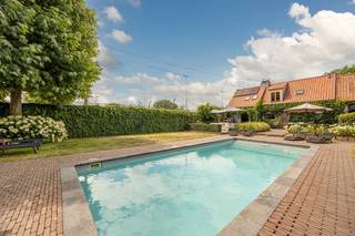 Sommige woningen moet je binnenstappen om te begrijpen. Deze is er zo één.<br /><br />Achter de met wingerd begroeide gevel van Spaans Fort 16 gaat een huis schuil dat authentieke charme moeiteloos verzoent met hedendaags comfort. Volledig gerenoveerd met oog voor detail, waarbij massieve materialen, warme haarden en kwalitatieve technieken samen één geheel vormen.<br /><br />Je komt binnen in een woning die meteen omarmt. Twee ruime, doorlopende leefruimtes liggen op een prachtige massieve eiken vloer, met tussenin een op maat gemaakte houten schuifdeur als karaktervol accent. Twee sfeerhaarden zorgen voor die onmiskenbare gezelligheid — en met in totaal vier haarden, gietijzeren radiatoren en authentieke terracotta in de eetkamer ademt elk hoekje warmte en klasse. Een groot schuifraam brengt de tuin naar binnen.<br /><br />De keuken, hoogwaardig uitgerust met onder meer een Lacanche-fornuis en natuurstenen werkblad, sluit naadloos aan op de eetkamer. Boven vind je een riante slaapkamer, een tweede slaapkamer met inloopkast, en een verzorgde badkamer met ligbad, dubbele wastafel en inloopdouche.<br /><br />Buiten wordt het pas echt genieten. Het verwarmde zwembad van circa 4 x 9,5 meter, met automatisch rolluik en recent vernieuwde technieken, vormt het kloppende hart van een klassevol aangelegde tuin met twee terrassen. Het volledig omgebouwde bijgebouw (ca 35 m2) met keuken, douche, zithoek en technische berging belooft urenlange feesten en zwoele zomeravonden.<br /><br />En het comfort zit ook in de cijfers: EPC-label B, conforme elektrische keuring, een nieuwe condensatieketel (2024) met boiler, ontkalker, 10 zonnepanelen en dakisolatie. De warmtepomp voor het zwembad werd geplaatst in 2010. De zwembadpomp werd vernieuwd in 2025 en de zandfilter in 2021. Daarnaast werd het zwembad ongeveer vier à vijf jaar geleden volledig opnieuw gepolyesterd, waardoor het technisch in perfecte staat verkeert. Parkeren doe je moeiteloos voor de deur en aan het bijgebouw.<br /><br />Authentiek wonen, vakantiegevoel het hele jaar door, op een steenworp van Antwerpen. Of je het bekijkt als een gezinswoning, luxe B&B of buitenverblijf, dit unieke huis laat zich niet samenvatten, enkel ontdekken.<br /><br />Alle attesten en plannen zijn te raadplegen op onze website bij documenten. <br /><br /><strong>Voor meer informatie (www.wellimmo.net ) of een bezichtiging mail info@wellimmo.net of tel 03 225 00 68.</strong><br /><br /><br />