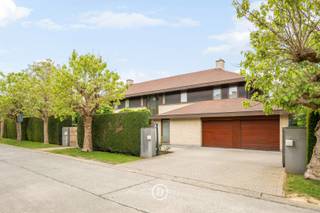Ontdek deze exclusieve villa in het gegeerde Domein van Bouchout te Wemmel, gelegen op een prachtig perceel van circa 25 are met optimale privacy. De woning, gebouwd in 2001, beschikt over een fraai aangelegd terras met een verwarmd buitenzwembad en geniet van een rustige, groene omgeving. Binnen werd gekozen voor hoogwaardige, duurzame materialen en uitgebreid maatwerk, wat resulteert in een stijlvolle en tijdloze afwerking. Dankzij het gunstige EPC-label B combineert deze eigendom exclusief wooncomfort met energiezuinigheid. Verder beschikt de villa over een inpandige garage, een ruime kelder met wijnkelder en meerdere buitenstaanplaatsen.<br /><br />De woning met een bewoonbare oppervlakte van 526 m2 is als volgt ingedeeld: <br /><br />0: Ruime inkomhal met gastentoilet, met in de linkervleugel een afzonderlijk bureau, een elegante ontvangstruimte met open haard en een gezellige tv-kamer. De rechtervleugel omvat een ruime eetkamer die aansluit op de volledig uitgeruste keuken met kwalitatieve afwerking. Aansluitend bevindt zich een praktische bijkeuken met wasruimte en veel ingebouwde opbergruimte, rechtstreeks verbonden met de garage. Op het gelijkvloers is bovendien een polyvalente kamer aanwezig die kan dienen als eerste slaapkamer of gastenkamer.<br /><br />+1: Op de eerste verdieping bevindt zich een ruime masterbedroom met dressing en een aansluitende badkamer, uitgerust met ligbad, douche, toilet en dubbel wasmeubel. De masterbedroom is bovendien voorzien van airconditioning. In de nachthal zijn er nog twee badkamers, waarvan één met ligbad en één met douche. Daarnaast zijn er drie ruime kinderkamers, elk afgewerkt met maatwerk en praktische inbouwoplossingen.