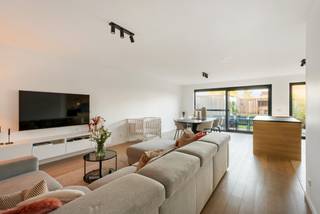 Appartement de plain-pied prêt à emménager d'environ 104 m² avec 2 chambres, jardin et 1 place de parking en surface, situé dans la Résidence De Prins.<br /><br />Hall d'entrée avec toilettes invitées et placard vestiaire intégré, salle de bains spacieuse avec douche à l'italienne et double lavabo, 2 chambres, salon lumineux avec parquet et porte-fenêtre donnant sur la terrasse, et une cuisine ouverte équipée (lave-vaisselle, plaque de cuisson vitrocéramique, four, réfrigérateur et hotte) avec buanderie attenante. <br />Terrasse avec jardin, abri de jardin et terrasse couverte près de l'abri de jardin.<br />Place de parking n° 10 à l'arrière incluse.<br /><br />Caractéristiques exceptionnelles :<br />- Chauffage au sol<br />- Local à vélos et à poubelles communs