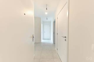 This energy-efficient new-build flat forms part of the prestigious Burenberg residential development in Leuven, a green and peaceful area within walking distance of the city centre and close to major access roads. <br /><br />This move-in-ready flat combines modern comfort, the latest technology and a practical layout with high-quality finishes.<br />The showpiece of the flat is the light-filled living area with open-plan kitchen. The large sliding window opens onto the spacious covered terrace, which leads onto a south-facing communal garden. The kitchen, featuring a cooking island, is fully fitted and thoughtfully finished with warm materials; there is also a utility room with a connection for a washing machine.<br /><br />The central hallway provides access to all other rooms in the flat. In addition to the two full-sized bedrooms, there is a separate toilet and a bathroom with a spacious walk-in shower. Here too, comfort is combined with attractive material choices and fine details such as indirect lighting.<br /><br />From the underground car park, you can take the lift directly to the apartment block. The parking space is available to rent for €100.<br /><br />In short, this apartment ticks all the boxes for anyone looking for a lovely place where high-quality living is combined with a central yet quiet location. <br /><br />Available immediately.<br />Rent: €1,450/month + €100/month (parking space) + €100/month service charges.