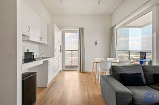 <p><span>Panoramisch wonen op de 18de verdieping aan het Eilandje</span></p><p><span>Op zoek naar een lichtrijk appartement met een uitzicht waar slechts weinigen van kunnen dromen? Op de 18de verdieping van een verzorgd appartementsgebouw aan de Ellermanstraat 61 bevindt zich dit aangename twee slaapkamerappartement met een indrukwekkend panoramisch zicht over de Antwerpse skyline en de dokken.</span></p><p><span>De lichtrijke leef- en eetruimte van ca. 32 m² wordt omringd door grote raampartijen en biedt voldoende plaats voor een comfortabele zit- en eethoek. Vanuit vrijwel elke hoek geniet u van het voortdurend veranderende uitzicht over Antwerpen. Aansluitend bevindt zich de volledig ingerichte open keuken, voorzien van een inductie kookplaat, dampkap, koelkast met diepvriesvak, microgolf en vaatwasser.</span></p><p><span>Het appartement beschikt over twee slaapkamers van respectievelijk ca. 12 m² en 9 m². De badkamer is uitgerust met een regendouche, lavabomeubel, spiegel en toilet. Daarnaast is er een extra, praktische berging met aansluitingen voor een wasmachine en droogkast.</span></p><p><span>Een absolute blikvanger is het royale terras dat zich rondom het appartement uitstrekt. Hier geniet u op verschillende momenten van de dag van de zon, de rust op hoogte en een uniek uitzicht over de stad en haar dokken.</span></p><p><span>Het appartement is volledig rolstoeltoegankelijk. Een privatieve parkeerplaats hoort bij het appartement en dient verplicht mee aangekocht te worden voor €30.000.</span></p><p><span> </span></p><p><span>Indeling</span></p><p><span>Lichtrijke leef- en eetruimte van ca. 32 m² met toegang tot het panoramisch terras van ca. 29m²</span></p><p><span>Volledig ingerichte open keuken voorzien van een inductie kookplaat, dampkap, koelkast met diepvriesvak, microgolf en vaatwasser.</span></p><p><span>Slaapkamer van ca. 12 m² op parketvloer met toegang tot het terras</span></p><p><span>Tweede slaapkamer van ca. 9 m² parketvloer met toegang tot het terras</span></p><p><span>Badkamer met inloop regendouche, lavabomeubel, spiegel en toilet</span></p><p><span>Extra berging met aansluitingen voor wasmachine en droogkast</span></p><p><span> </span></p><p><span>Belangrijkste troeven</span></p><ul><li><span>Gelegen op de 18de verdieping</span></li><li><span>Adembenemend uitzicht over Antwerpen en de dokken</span></li><li><span>Grote raampartijen en uitzonderlijk veel lichtinval</span></li><li><span>Royaal terras rondom het appartement</span></li><li><span>Twee slaapkamers</span></li><li><span>Volledig rolstoeltoegankelijk</span></li><li><span>Goed onderhouden gemeenschappelijke delen</span></li><li><span>Privatieve parkeerplaats verplicht mee aan te kopen</span></li></ul><p><span> </span></p><p><span>Algemene informatie</span></p><p><span>Elektriciteit met privatieve verbruiksmeter</span></p><ul><li><span>Elektrische installatie: conform</span></li><li><span>EPC: A-label </span></li><li><span>Asbestattest: niet van toepassing</span></li></ul><p><span> </span></p><p><span>Het gebouw</span></p><p><span>Het kwalitatieve en goed onderhouden appartementsgebouw omvat een ondergrondse verdieping met parkeerplaatsen en bergingen, een gelijkvloerse verdieping en 21 verdiepingen met appartementen. Het gebouw beschikt over meerdere liften en een videofoonsysteem.</span></p><p><span> </span></p><p><span>Ligging</span></p><p><span>Het appartement bevindt zich op een uitstekende locatie nabij de Antwerpse dokken en het bruisende Eilandje. Winkels, scholen, horeca en openbaar vervoer liggen op wandelafstand. Ook het historische stadscentrum en de Antwerpse Ring zijn vlot bereikbaar.</span></p><p><span>Een uitzonderlijke woonplek voor wie ruimte, licht, comfort en een spectaculair uitzicht over Antwerpen weet te waarderen.</span></p><p><span> </span></p><p><span>De informatie in deze prospect is ter informatieve titel: de kandidaat-kopers moeten hun eigen zaak maken van het verkrijgen, controleren en interpreteren van deze informatie.</span></p><p><span> </span></p>