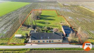 TORHOUT - Landelijk gelegen te renoveren langgevelwoning<br /><br />Het te renoveren woonhuis met loods is rustig gelegen te midden van weilanden en natuur, op een zon georiënteerd perceel van +- 65 are. Deze eigendom combineert ruimte, privacy en een landelijke ligging met heel wat potentieel.<br /><br />De gelijkvloerse verdieping van de woning heeft een oppervlakte van ca. 181m² en omvat een ruime living, eetkamer, ingerichte keuken, berging/wasplaats, badkamer, afzonderlijk toilet en drie slaapkamers. Vanuit de woning is er rechtstreeks toegang tot de zuidwestgerichte tuin, waar u in alle rust kan genieten van de groene omgeving. Aansluitend bevindt zich een vergunde garageloods van ca. 115m², die extra mogelijkheden biedt voor opslag, werkruimte of hobbydoeleinden.<br /><br />Op de eerste verdieping is er een ruime zolder die nog kan worden ingericht, wat bijkomend uitbreidingspotentieel biedt voor de woning.<br /><br />De eigendom beschikt over stadswater en wordt verwarmd met propaangas en een pellet kachel. Daarnaast is er ook een waterput aanwezig.<br /><br />De grote bebouwde oppervlakte, de vergunde loods en de uitzonderlijk rustige ligging vormen de belangrijkste troeven van deze eigendom. <br /><br />Algemene informatie: EPC-score F, gelegen in agrarisch gebied, niet overstromingsgevoelig en niet gelegen in watergevoelig openruimtegebied.<br /><br />Voor meer informatie of een bezoek, kan u ons steeds contacteren: 053/60.65.66.