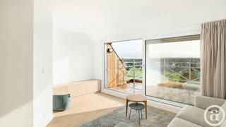 Dit prachtig gerenoveerde penthouse bevindt zich op de prestigieuze Kustlaan en combineert luxueus wooncomfort met een adembenemend uitzicht over Het Zoute.<br /><br />Bij binnenkomst wordt de aandacht meteen getrokken naar de lichtrijke leefruimte, waar een open, volledig uitgeruste keuken naadloos aansluit op de woonkamer. De keuken is voorzien van een vaatwasser, een combi-oven en een ruime koelkast met vriesvak. Dankzij de grote raampartijen geniet de woonkamer van een overvloed aan natuurlijk licht en een panoramisch uitzicht over de omgeving. Vanuit deze ruimte is er toegang tot het ruime en zonnige terras, dat door zijn optimale oriëntatie de hele dag door van zonlicht profiteert, zowel op het terras zelf als in het appartement.<br /><br />Op de gelijkvloerse verdieping bevinden zich een gastentoilet en een ruime berging. Verder is hier ook een slaapkamer met elektrische rolluiken die de kamer volledig verduisteren. Deze slaapkamer beschikt over een ensuite douchekamer met toilet en een ingebouwde dressing. Vanuit de kamer is er toegang tot een tweede, noordelijk, terras.<br /><br />Op de eerste verdieping bevinden zich twee bijkomende slaapkamers, elk met een eigen ensuite douchekamer en toilet. Eén van de kamers is ruim genoeg voor twee dubbele bedden, wat extra comfort biedt voor gasten of een groter gezin. Op deze verdieping is er ook een extra bergruimte, waar de aansluitingen voor een wasmachine en droogkast reeds geïnstalleerd zijn.<br /><br />Alle slaapkamers zijn uitgerust met ingemaakte kasten, wat zorgt voor extra opbergruimte en een strakke afwerking. Dit penthouse biedt een unieke combinatie van luxe, ruimte en een uitstekende ligging, ideaal voor wie op zoek is naar een uitzonderlijke woonervaring aan de kust. <br /><br />Bovendien is het mogelijk een garage aan te kopen bij dit appartement.