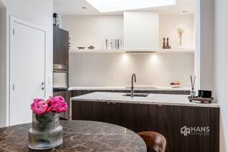 <p><span>Unieke charme, een hoogwaardige renovatie en een uitstekende ligging: deze karaktervolle stadswoning heeft het allemaal. Gelegen in een rustige, verkeersluwe straat woon je hier midden in de stad, met een school op 10m afstand en vlakbij winkels, horeca en openbaar vervoer. Ook de Ring en de stadsrand bereik je in een mum van tijd. De ideale uitvalsbasis voor wie het bruisende stadsleven wil combineren met rust en comfort.</span></p><p><span>De woning werd in 2021 volledig gerenoveerd met oog voor detail en afgewerkt met duurzame, kwalitatieve materialen. Daarbij werden onder meer de leidingen, elektriciteit, verwarming, vloeren, bezetting en de daken volledig vernieuwd. Voor zo veel mogelijk lichtinval werd er een skylight met hoogrendementsglas boven de keuken en tweede verdieping geplaatst. Daarnaast zijn de tussenvloeren geïsoleerd, werd de achtergevel in 2023 extra geïsoleerd en geniet je van een gunstige EPC-score B. Vooraan op het gelijkvloers zijn bovendien elektrische rolluiken voorzien en doorheen de woning is er ingebouwde Serax-verlichting aanwezig.</span></p><p><span>Via de stijlvolle inkomhal met elegante rasico-afwerking bereik je de gezellige leefruimte met open keuken van 47 m². De hoogwaardige afwerking met kalkbepleistering, eikfineer, graniet en microtopping zorgt voor een stijlvolle, warme en eigentijdse uitstraling. De open keuken is volledig uitgerust met kwalitatieve AEG-toestellen, Novy dampkap en een Quooker kraan. Op het gelijkvloers bevindt zich eveneens een apart gastentoilet.</span></p><p><span>De eerste verdieping omvat een ruime slaapkamer van 18 m² met een op maat gemaakte ingebouwde kast. Daarnaast bevindt zich de luxueuze badkamer van 11 m² met vrijstaand bad, inloopdouche, dubbele lavabo en toilet. De vloer-en muurafwerking in de badkamer is voorzien van microtopping. Op de bovenverdieping bevindt zich de royale masterbedroom van 35 m², die eenvoudig kan worden opgesplitst in twee volwaardige slaapkamers. Tot slot beschikt de woning nog over een praktische kelder van 30 m².</span></p><p><span>Ben je op zoek naar een instapklare stadswoning boordevol karakter, met een unieke afwerking en hedendaags wooncomfort? Mis deze kans niet! Voor meer info of een gratis schatting surf naar www.hansimmo.be</span></p><p><span> </span></p>